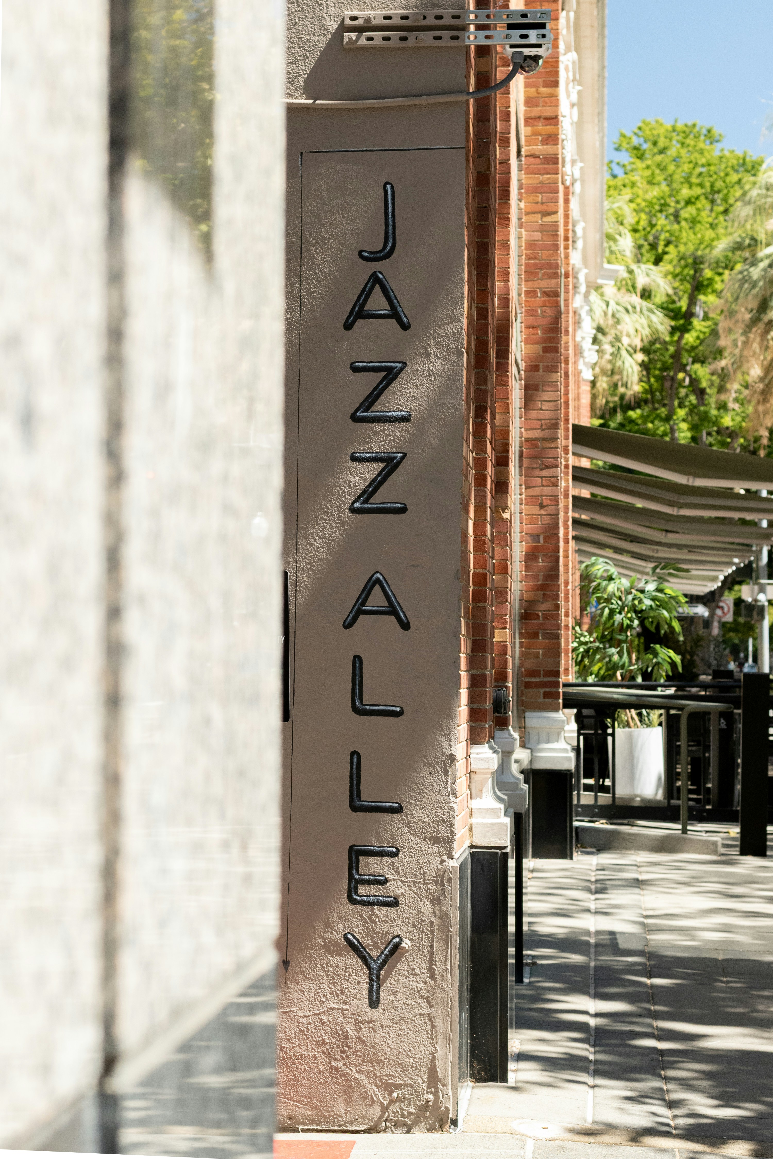 A vertical "jazz alley" sign on a building wall