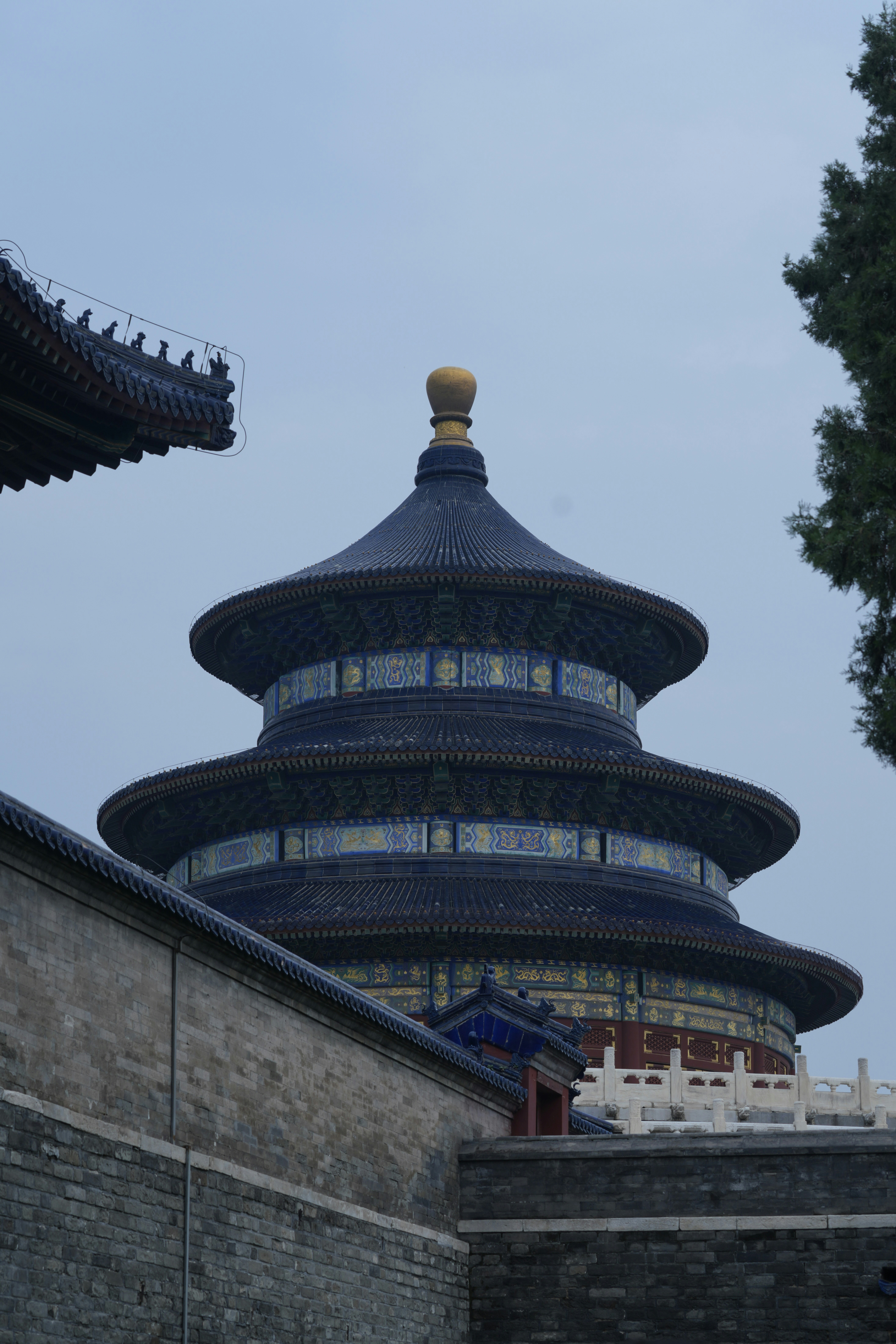 Traditional chinese temple building with blue roof and golden finial.