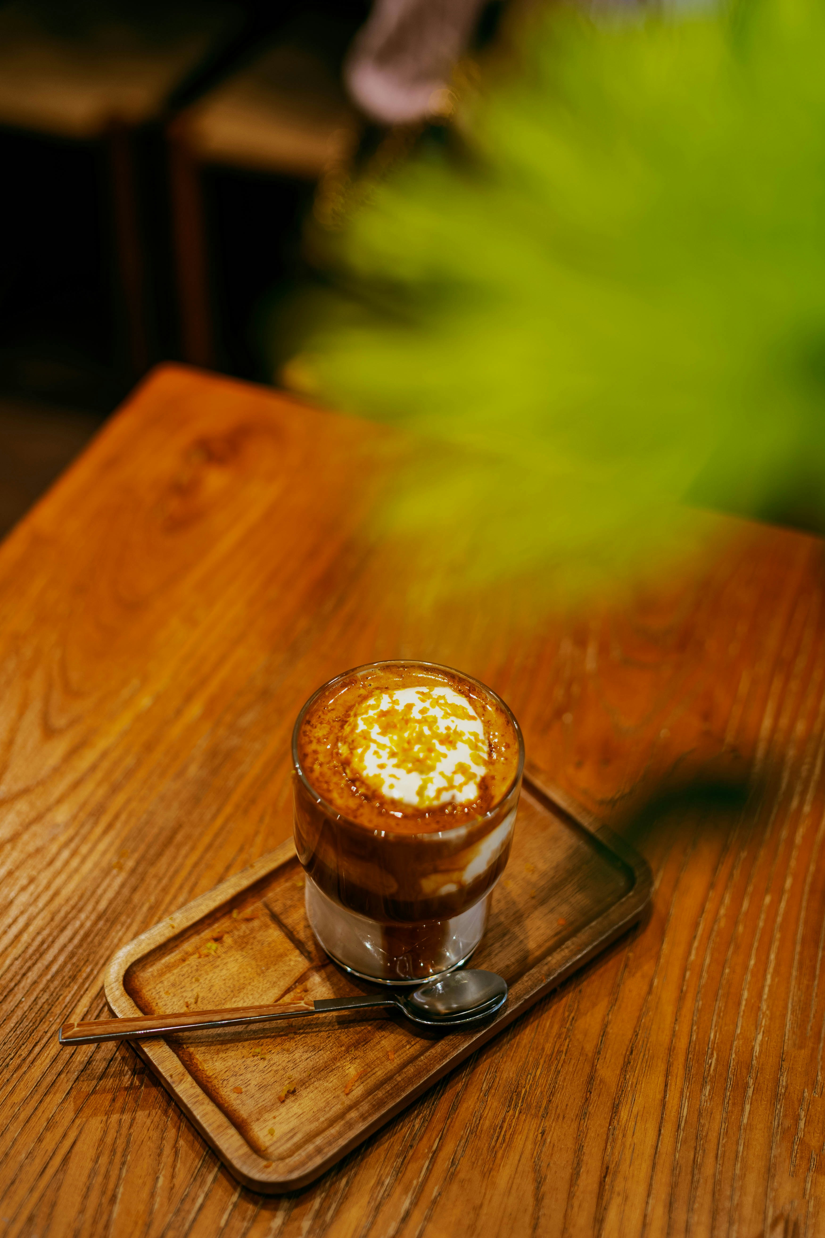 Glass of coffee with cream on a wooden table