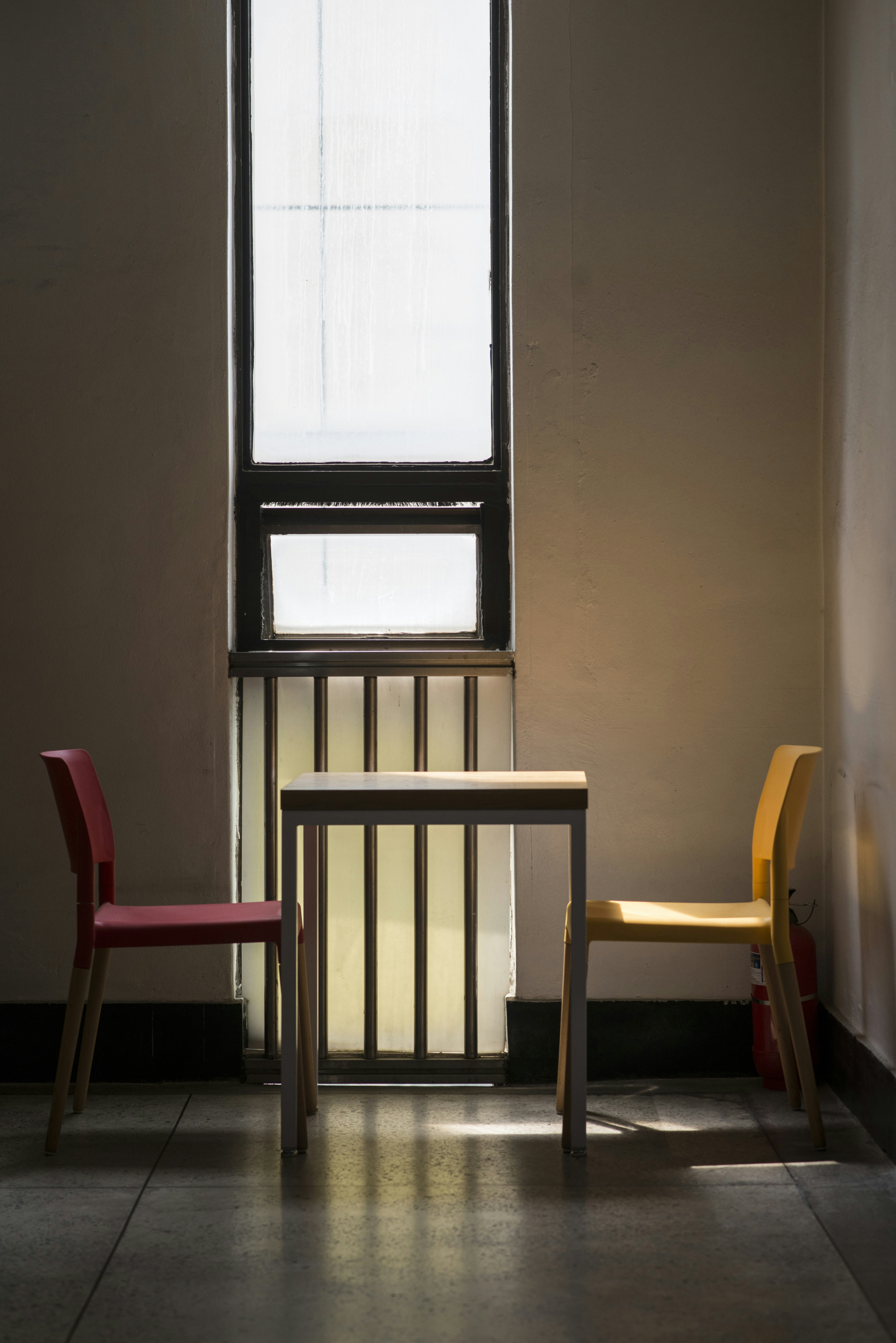 A small table and two chairs by a sunlit window