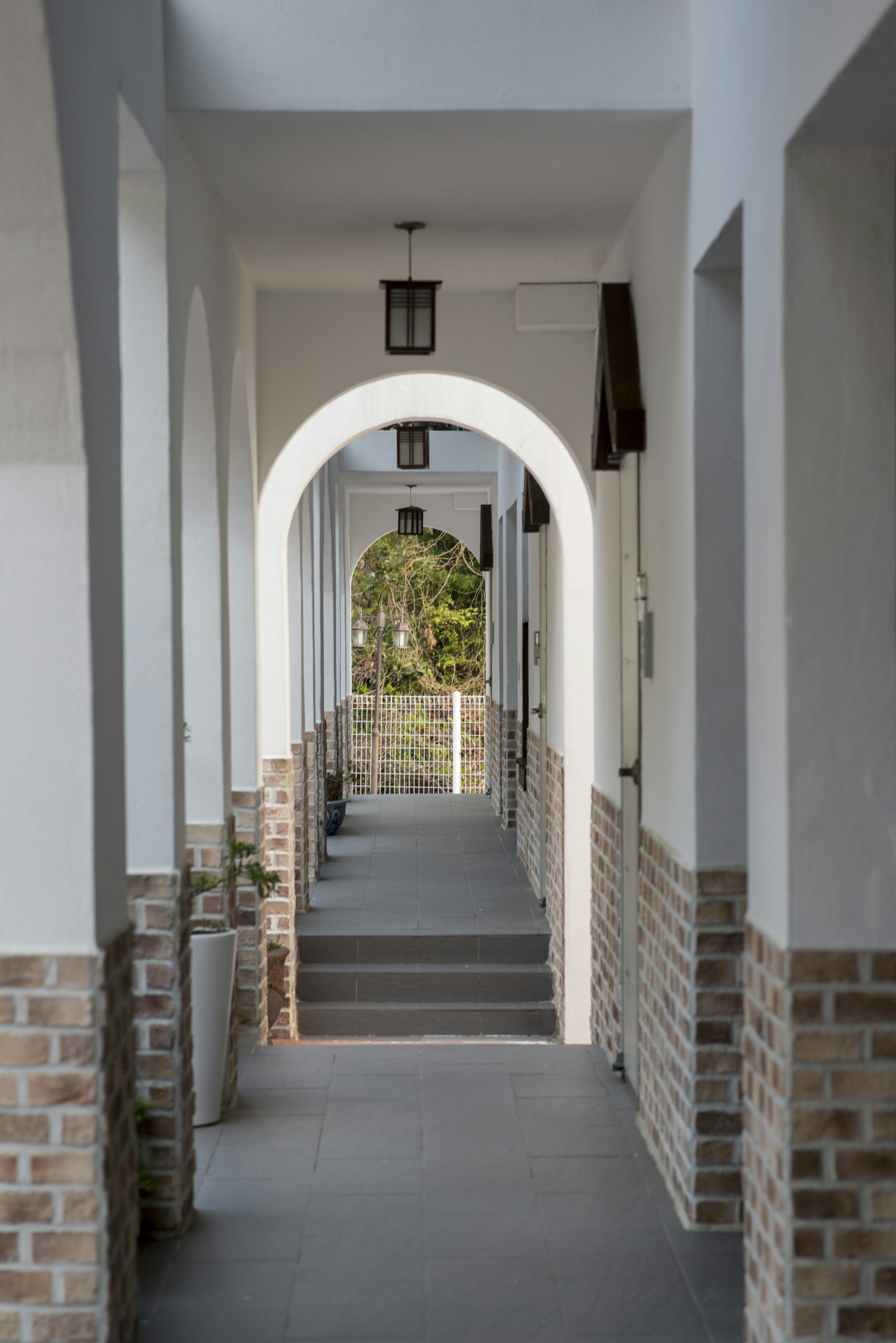 White arched hallway with brick accents leading to outdoor steps
