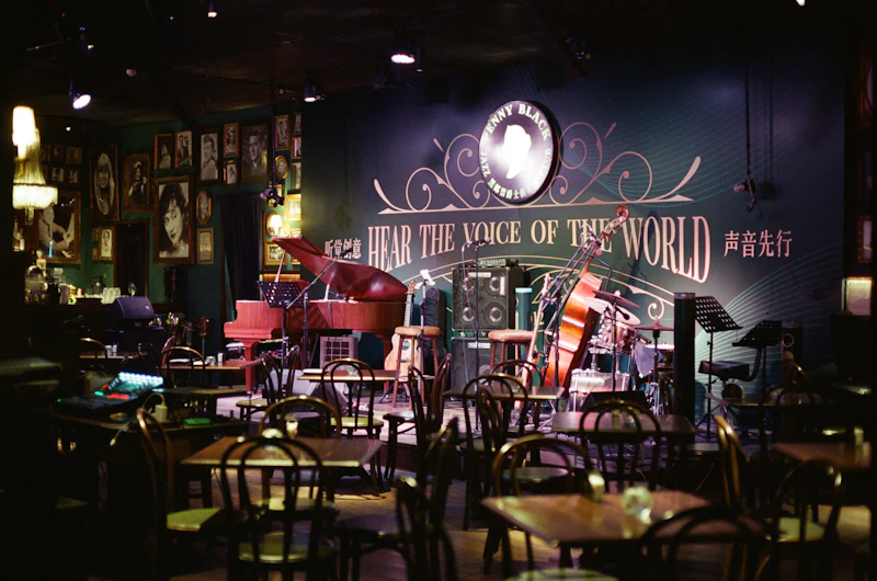 A dark music room with a piano on stage