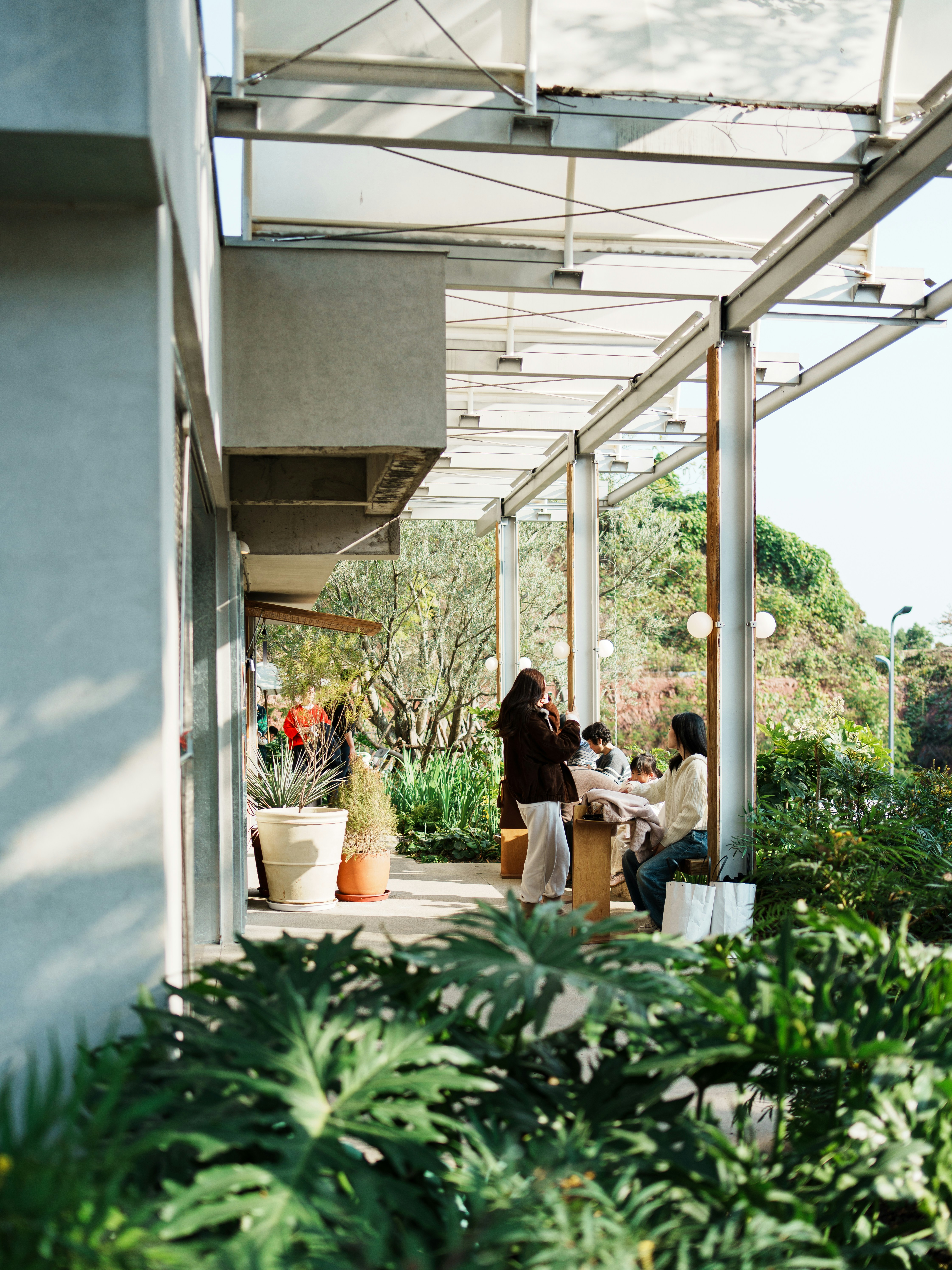 Women relaxing on a modern outdoor patio surrounded by plants.