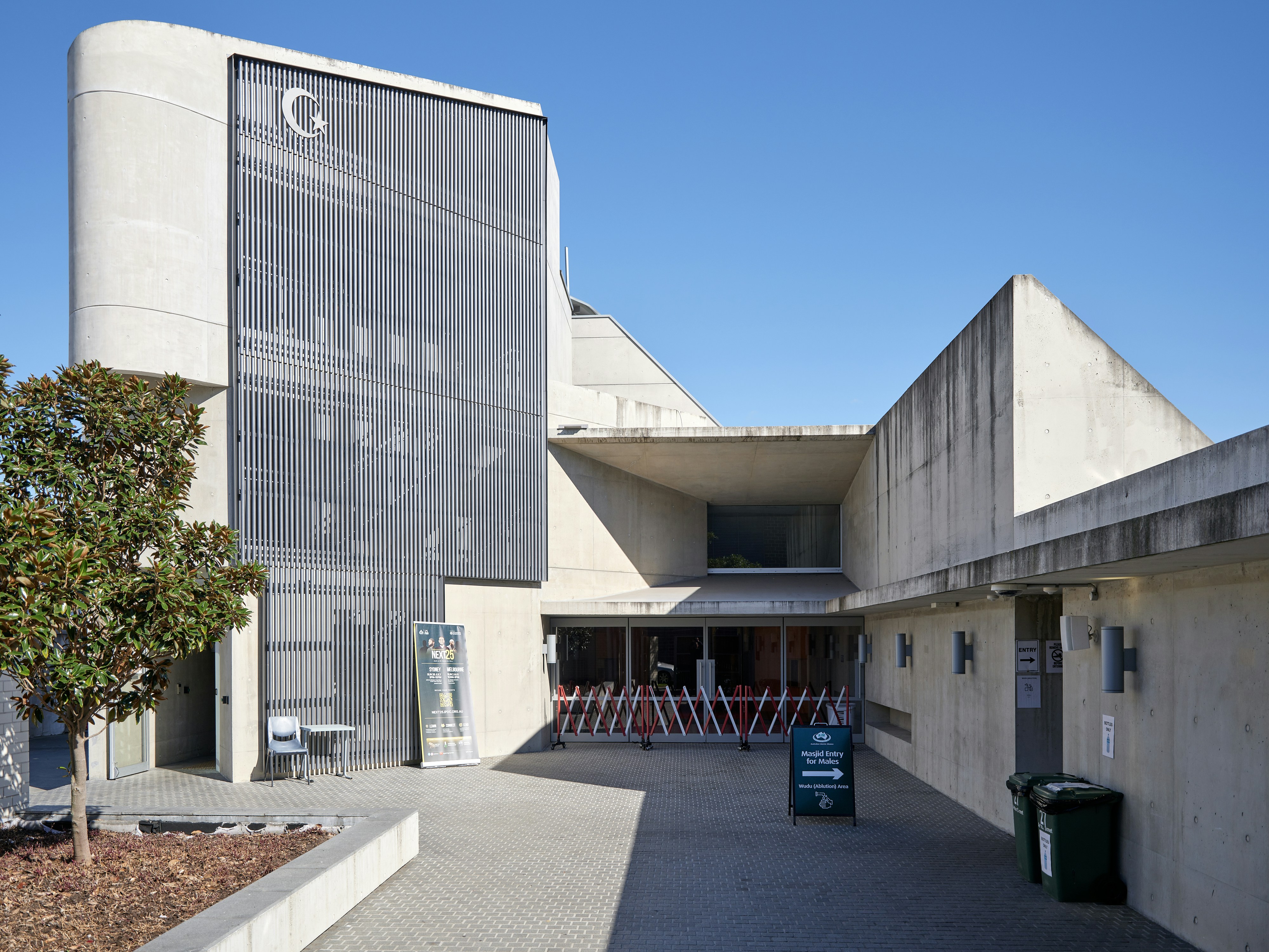 Modern concrete building with a crescent symbol under blue sky