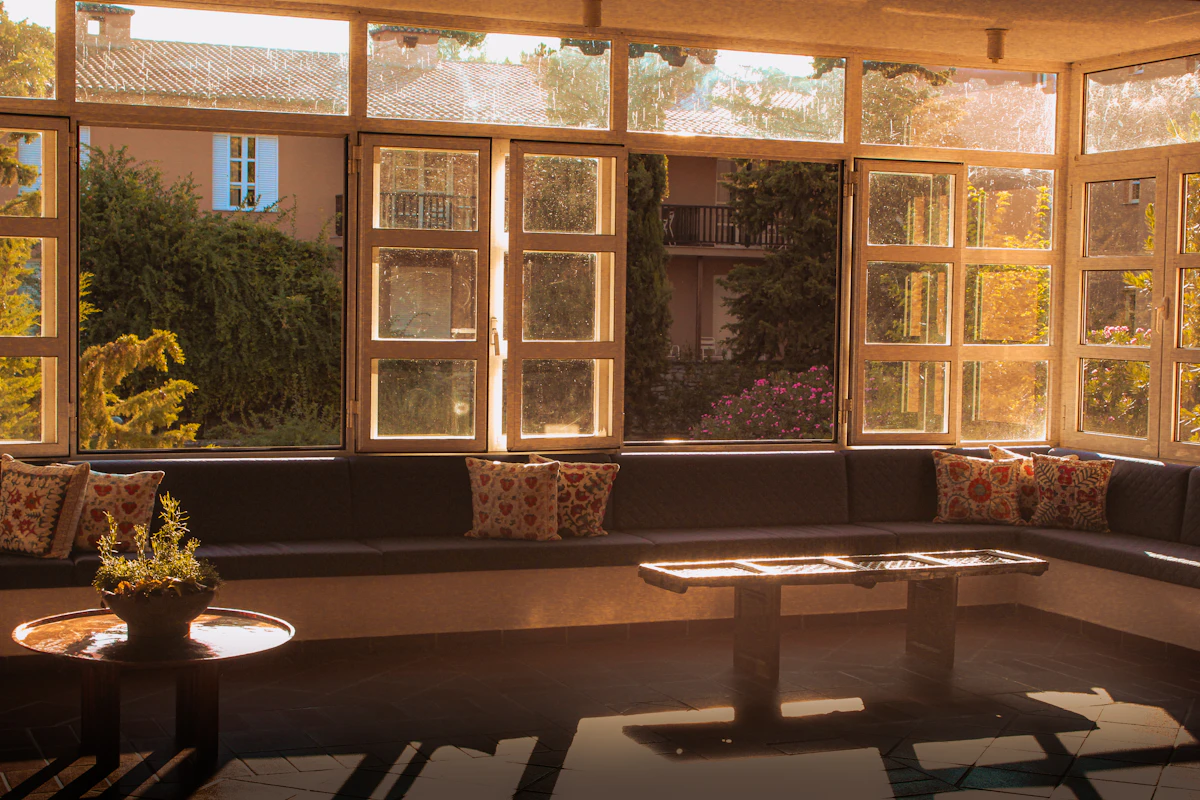 A bright sunroom with large windows looking out over a lush garden