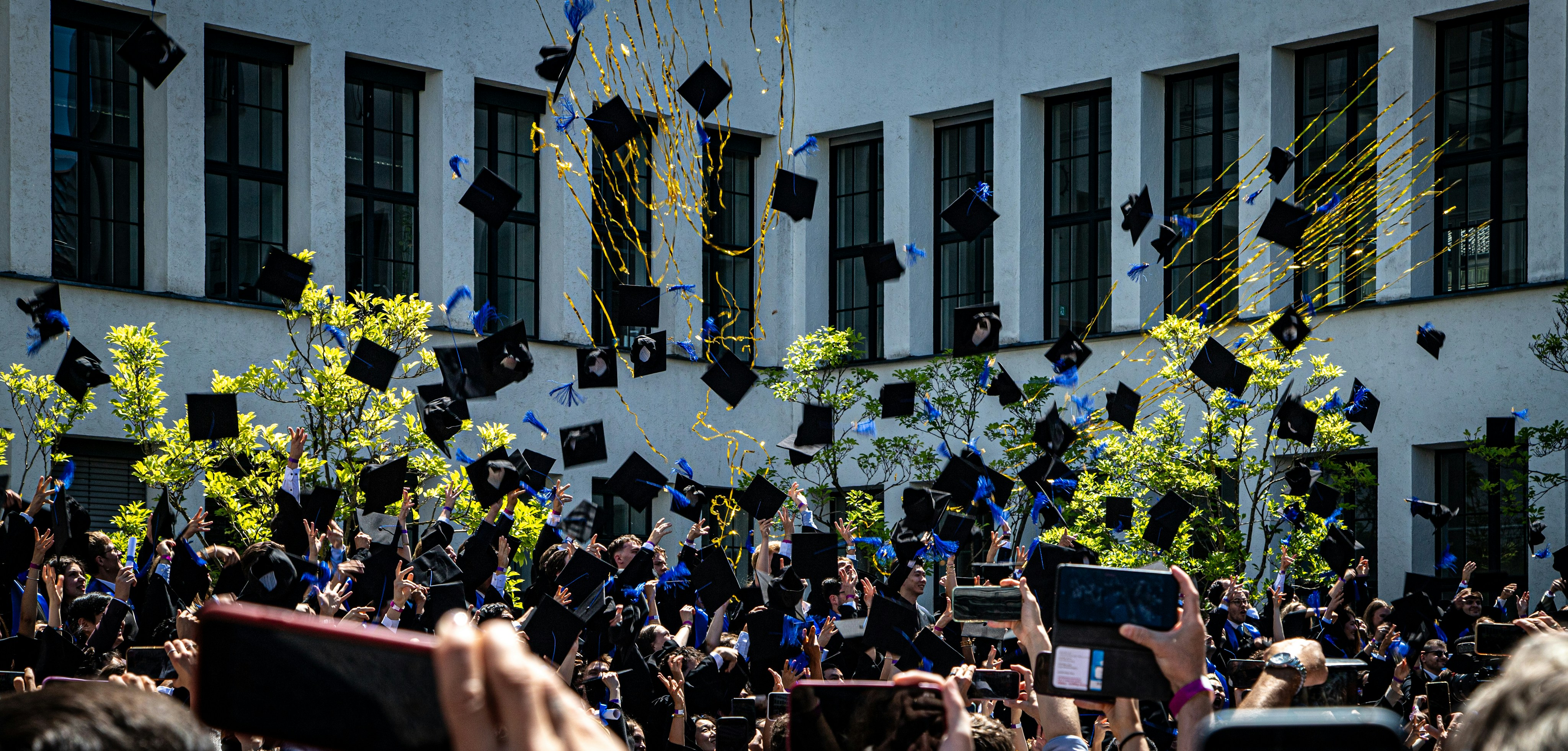 Graduates throwing caps in the air during a ceremony.