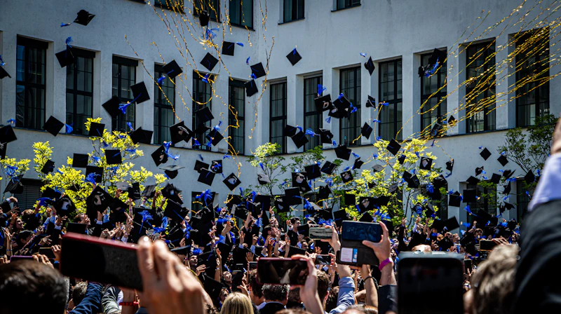 Des diplômés lançant des casquettes en l’air lors d’une céré