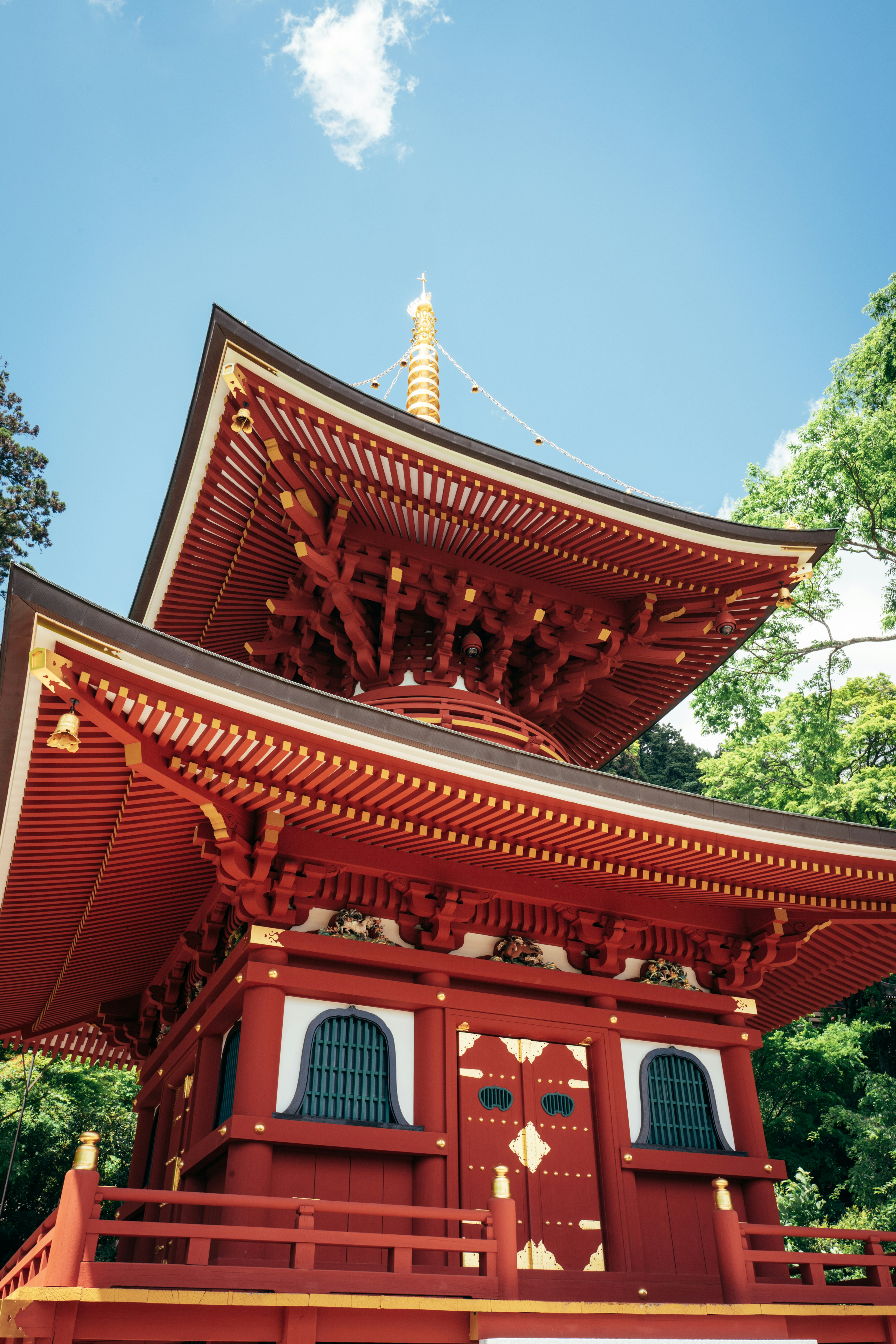 Vibrant red japanese pagoda against a clear blue sky