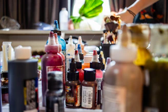 Numerous colorful ink and paint bottles on a table