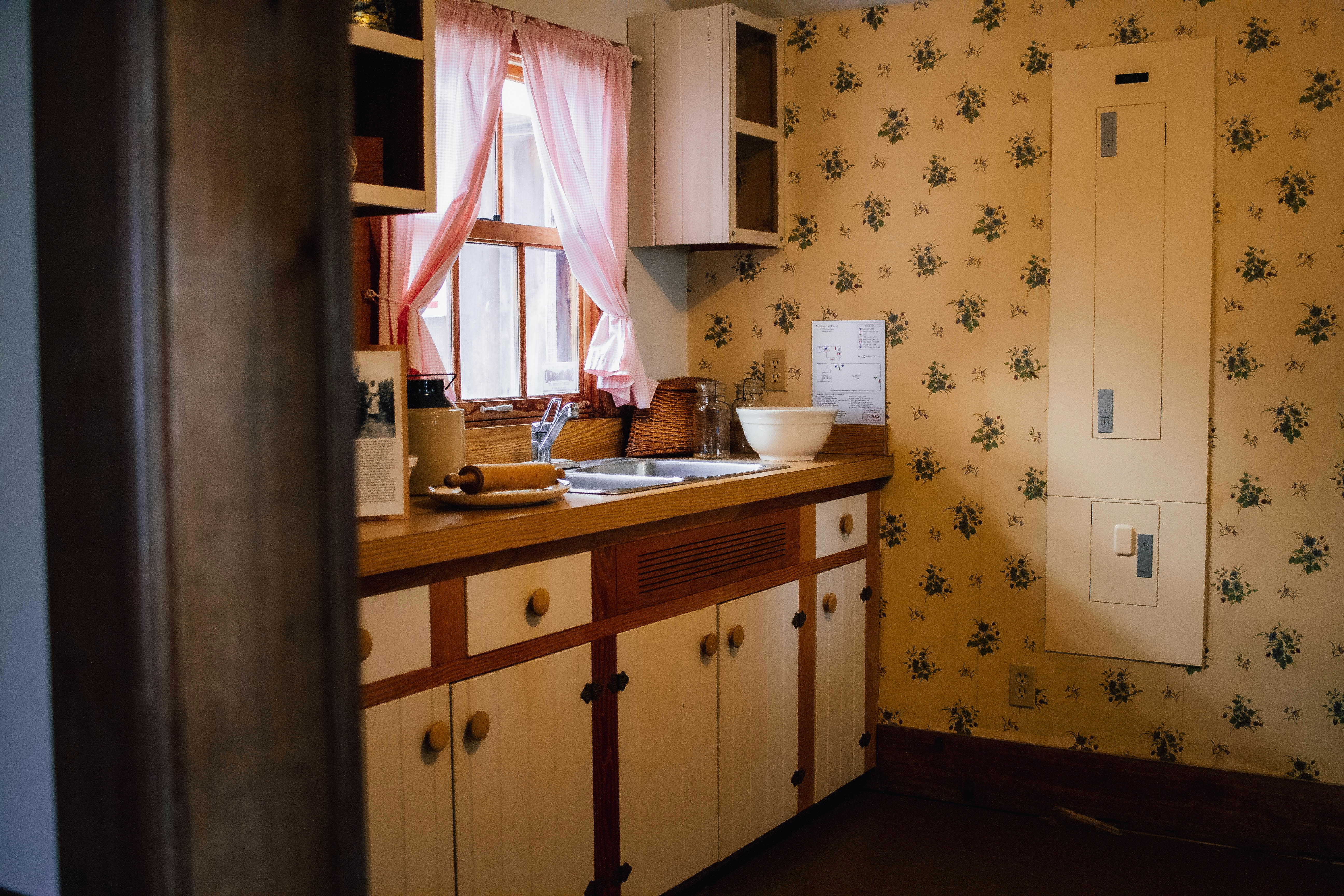 Before: A dated kitchen with papered walls and original units, before work