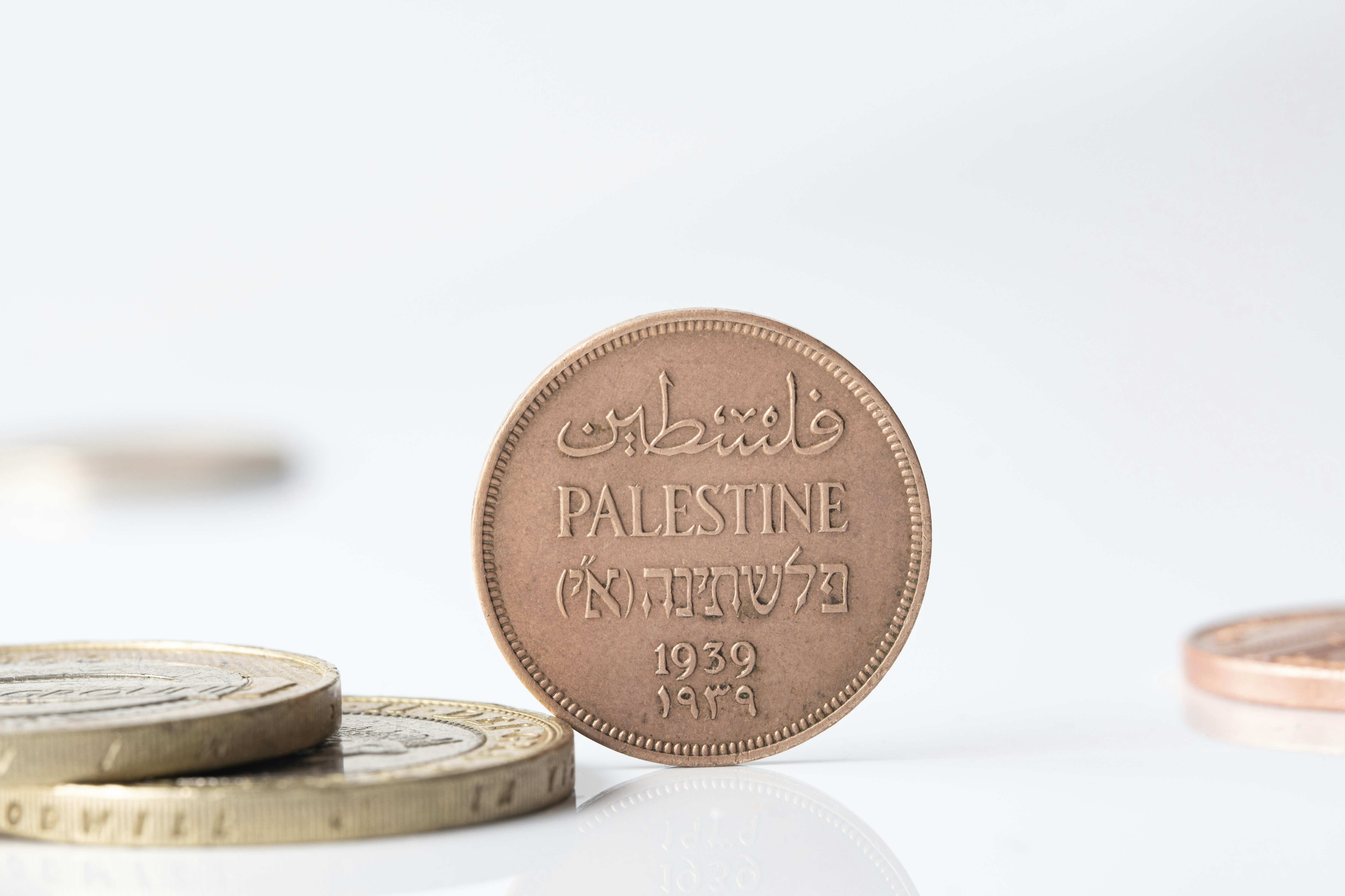 Vintage palestine coin from 1939 standing on white background.