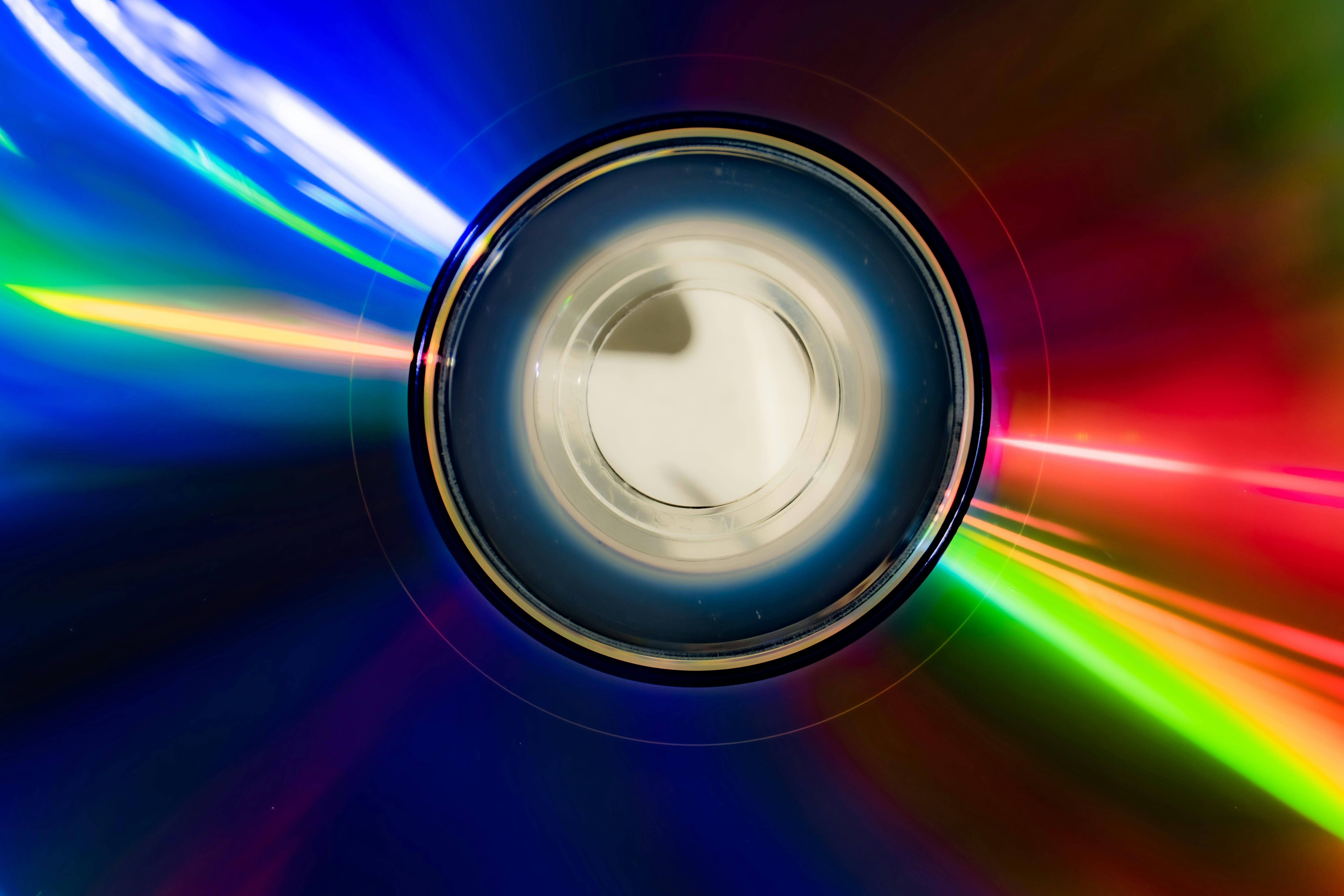 Reflective cd surface with vibrant blue, green, and red light.
