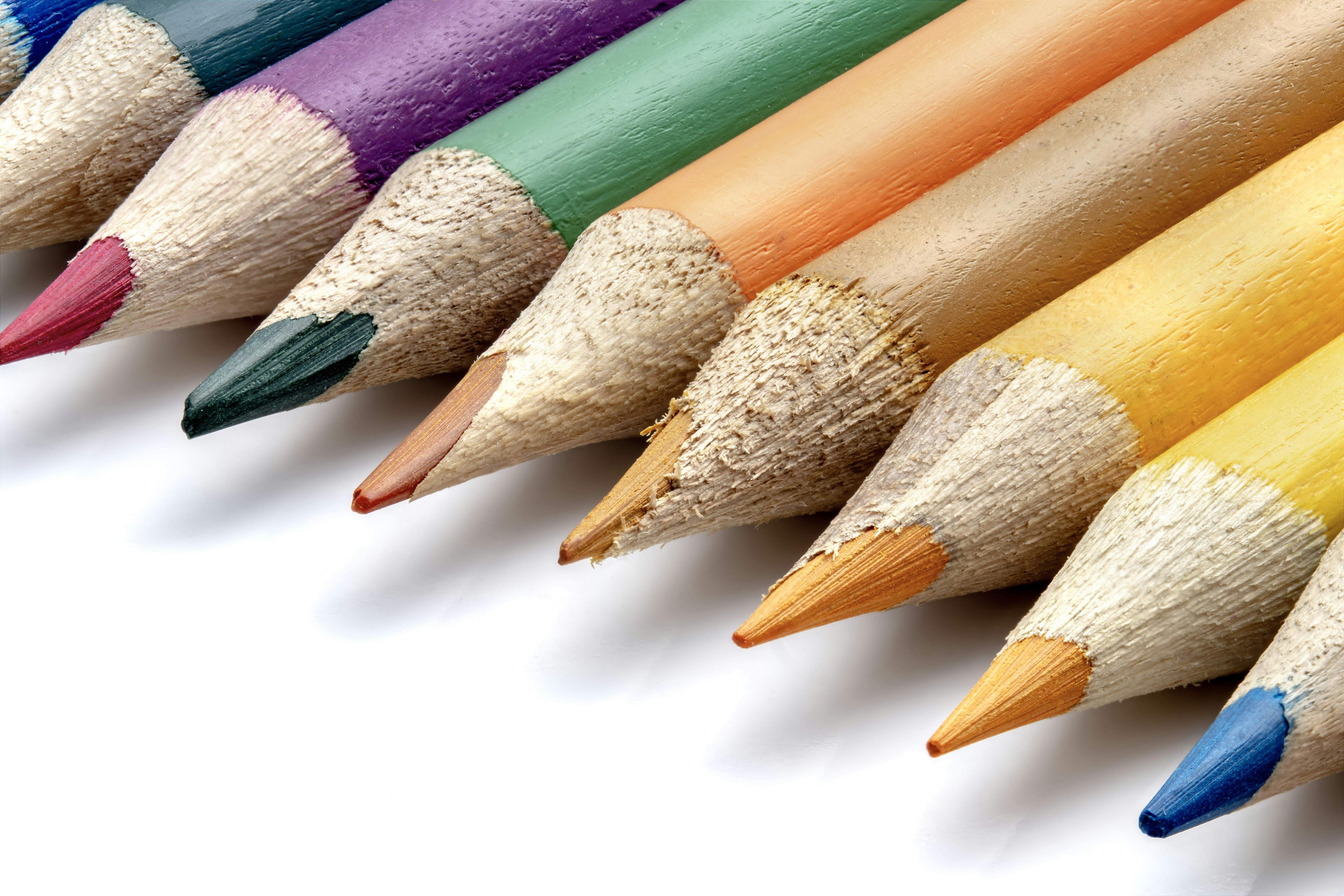 A row of colorful sharpened pencils on a white background
