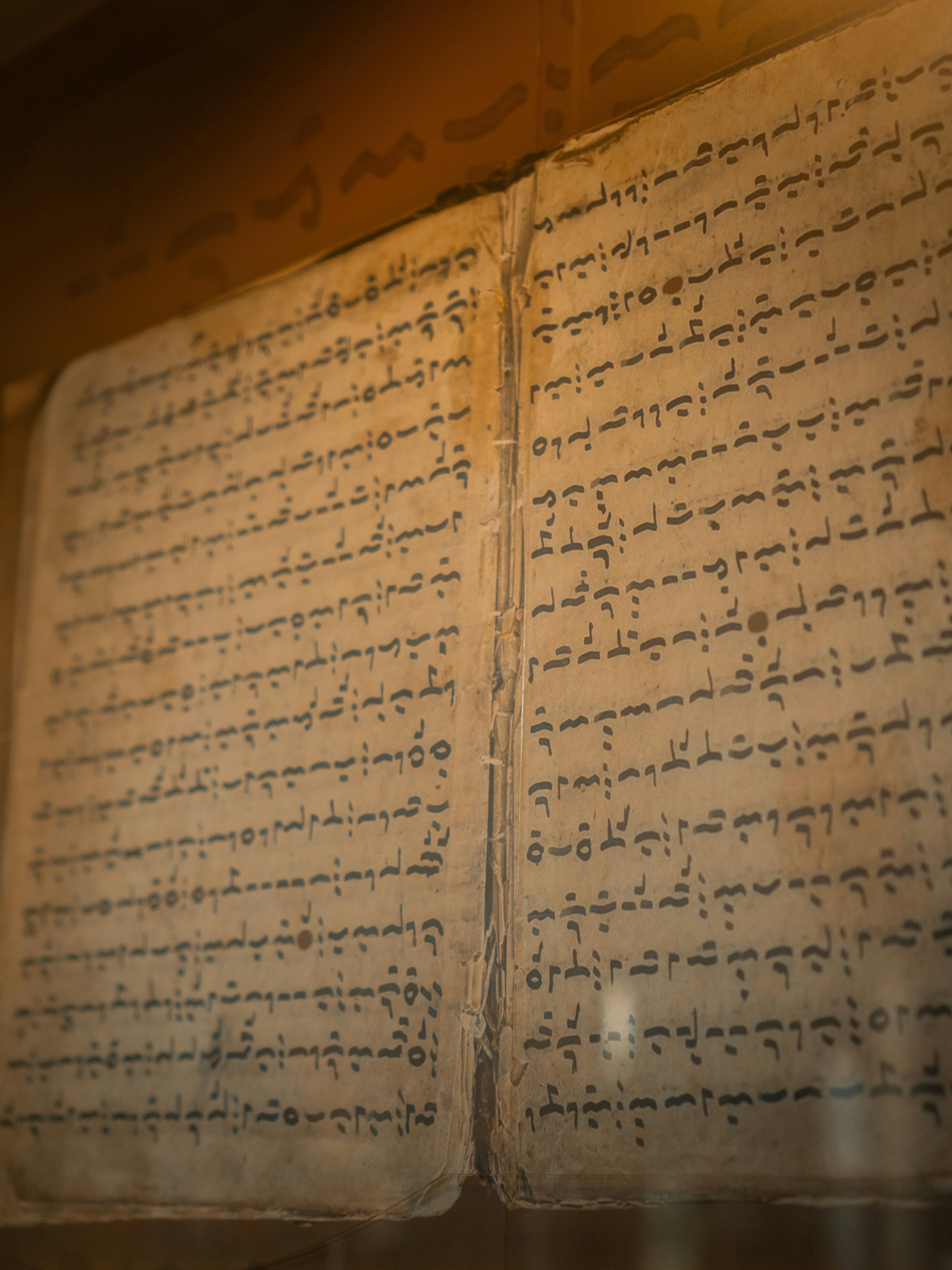 An ancient open book displaying intricate, aged script.