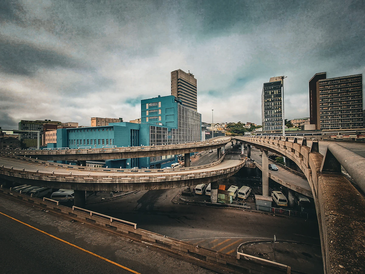 Highway interchange with city buildings under a cloudy sky