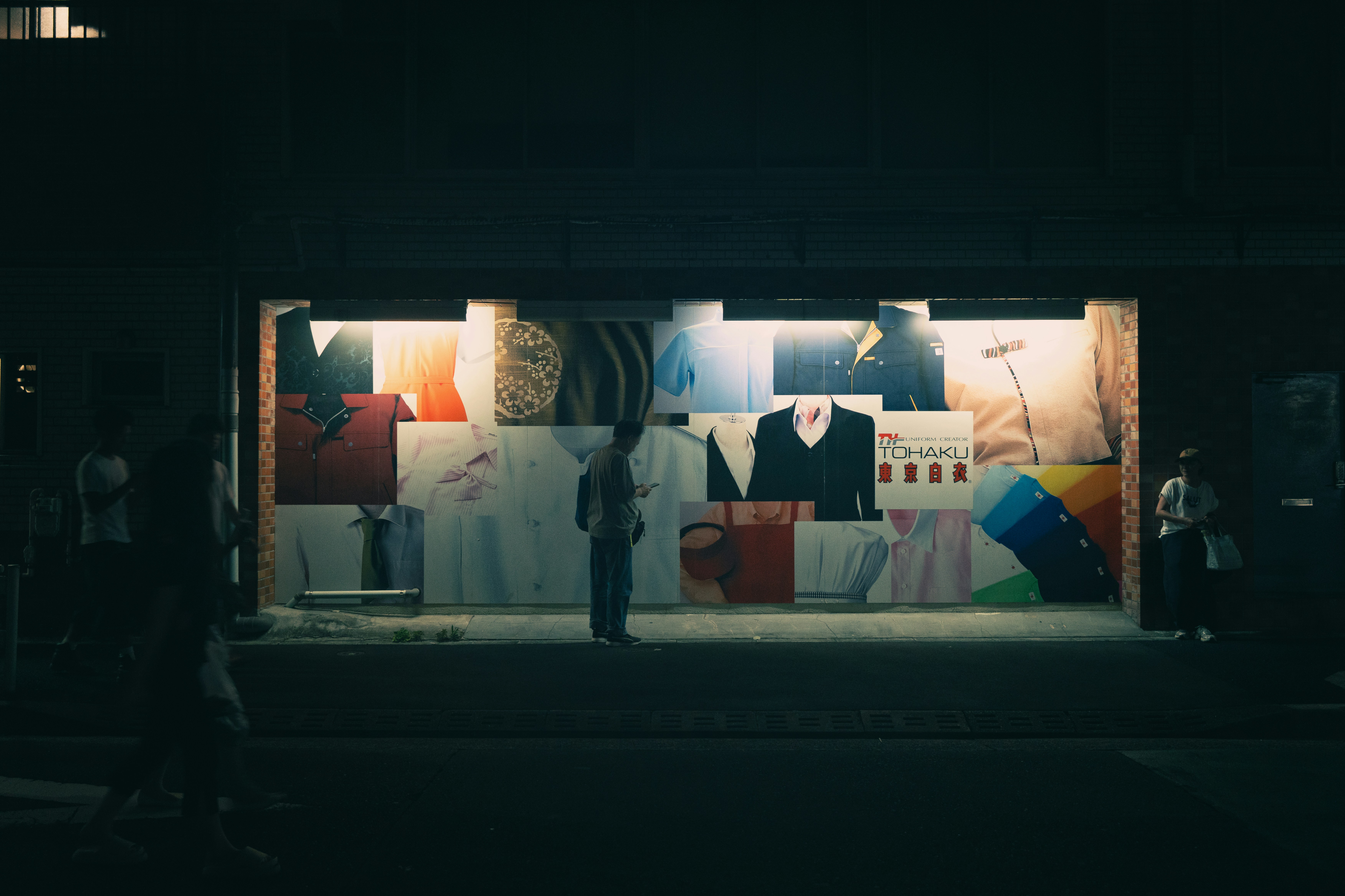 Colorful items displayed in a lit storefront window at night.