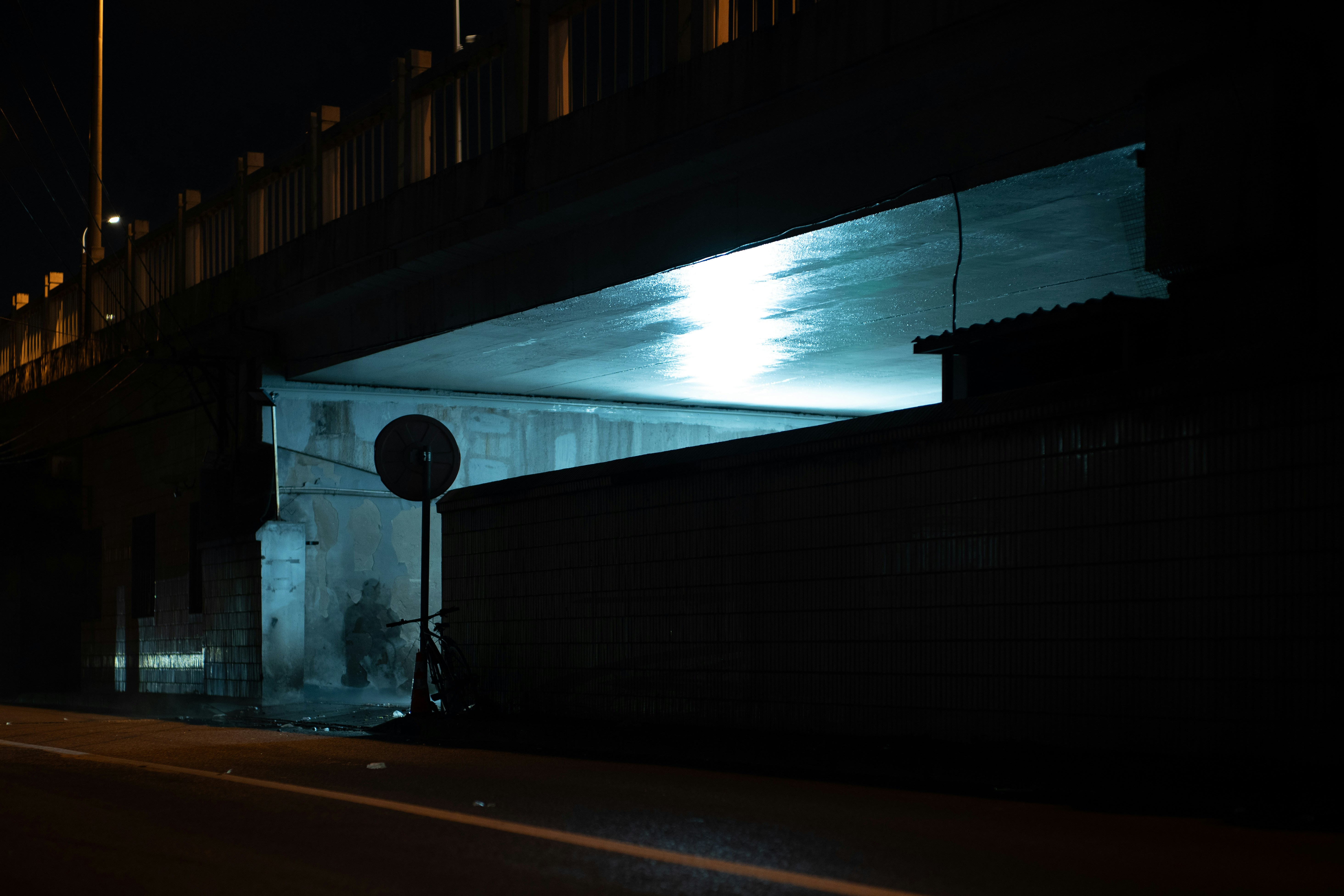 Dark underpass with blue light at night.