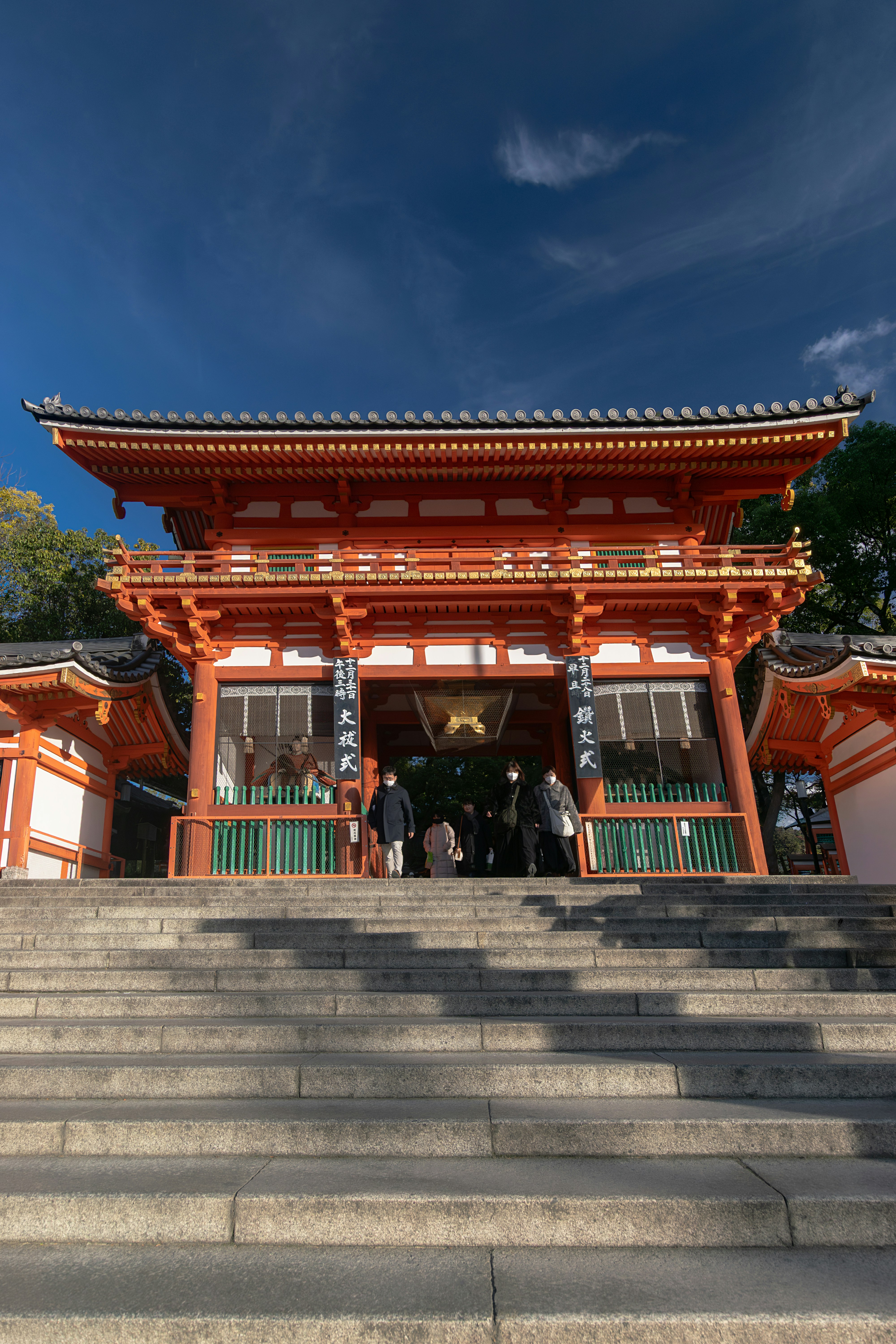 Ornate japanese temple gate with steps under a blue sky.