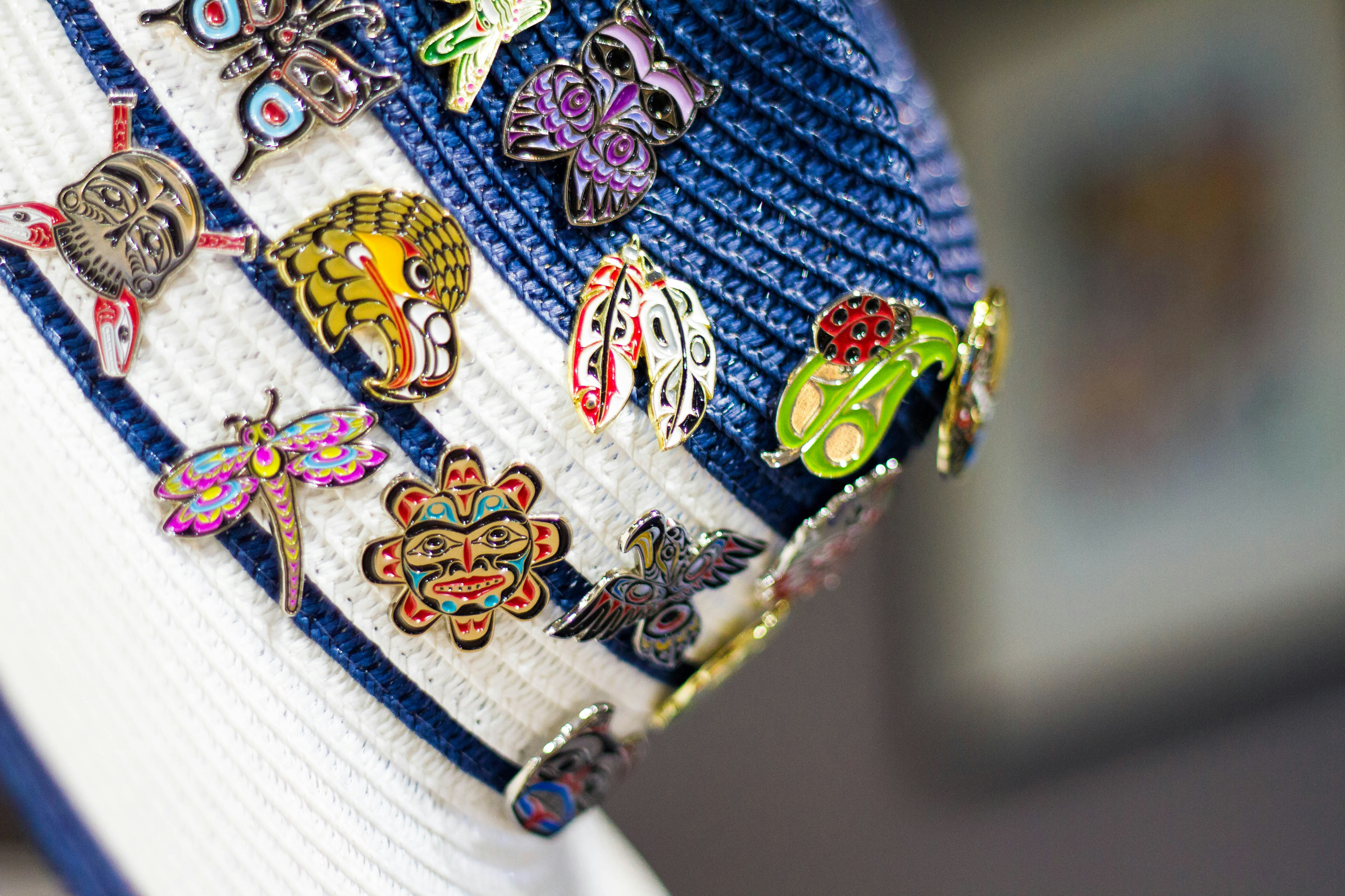 Colorful insect and abstract pins on a striped fabric.