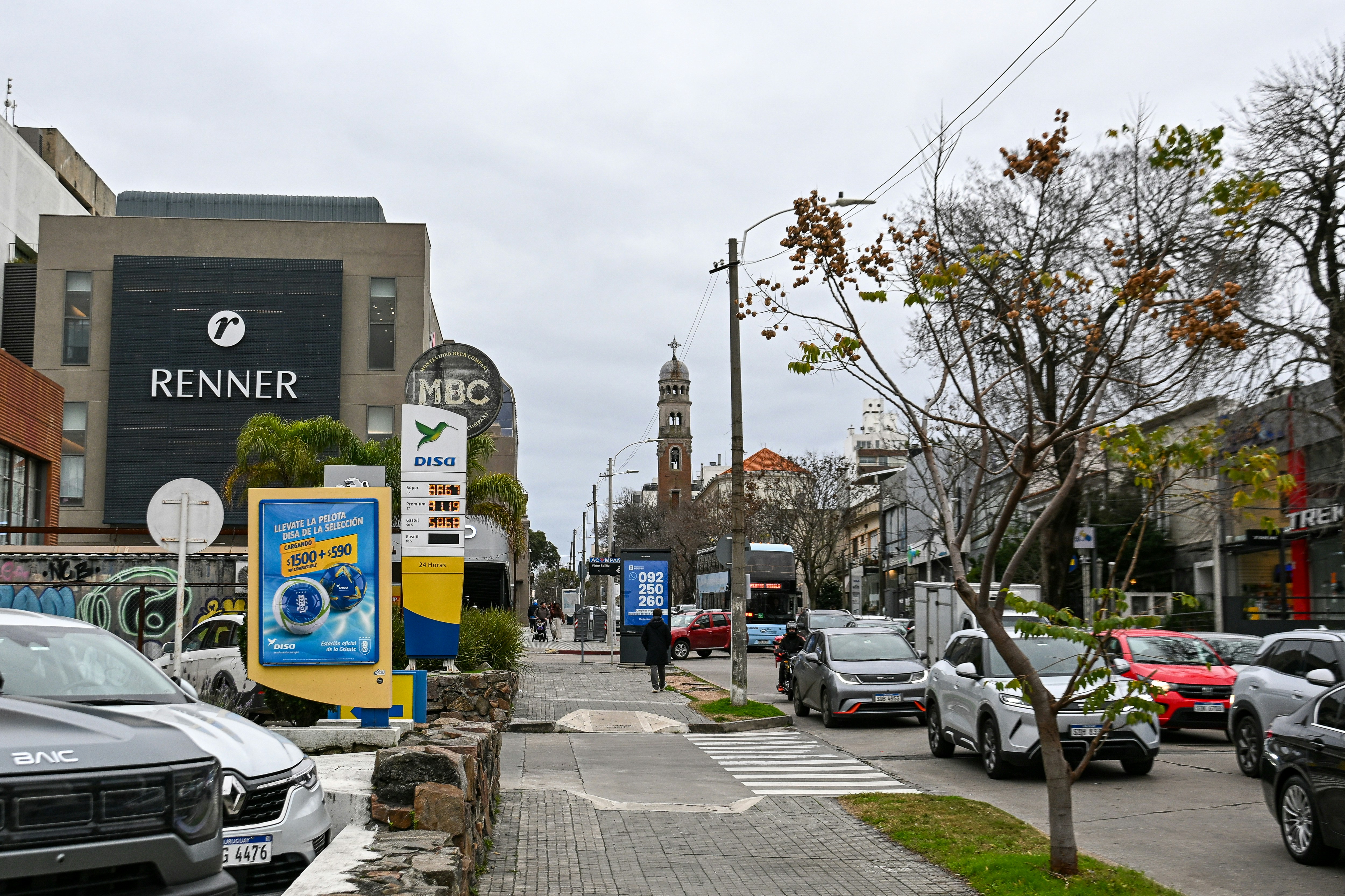 A busy street with cars, buildings, and a distant tower.