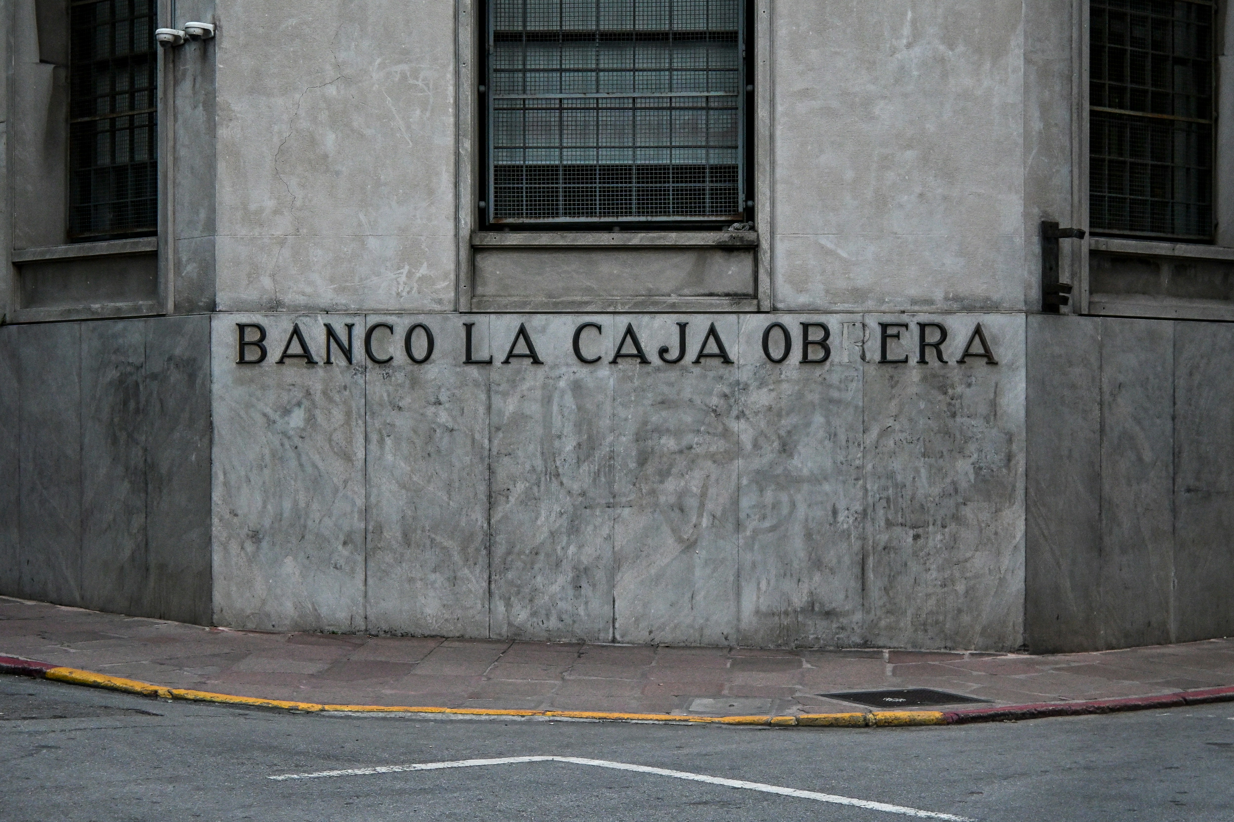 Banco la caja obrera sign on a weathered building corner.