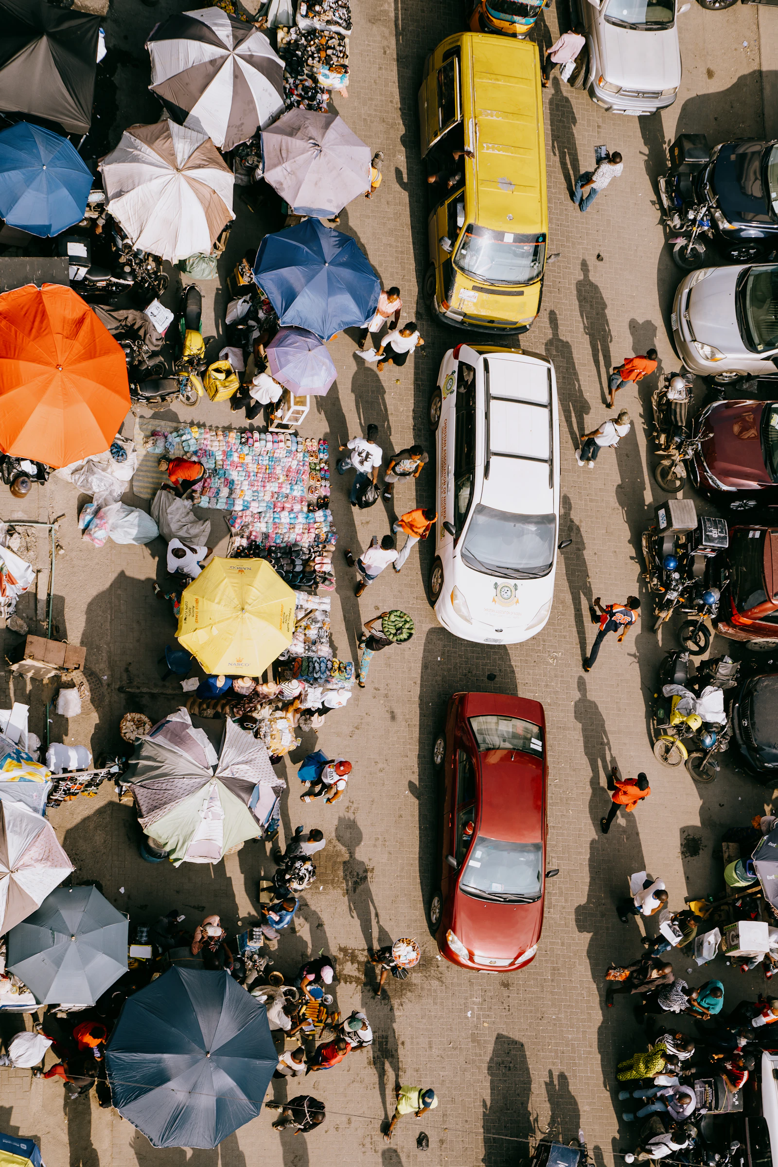 Aerial view of a bustling street market with colourful umbrellas