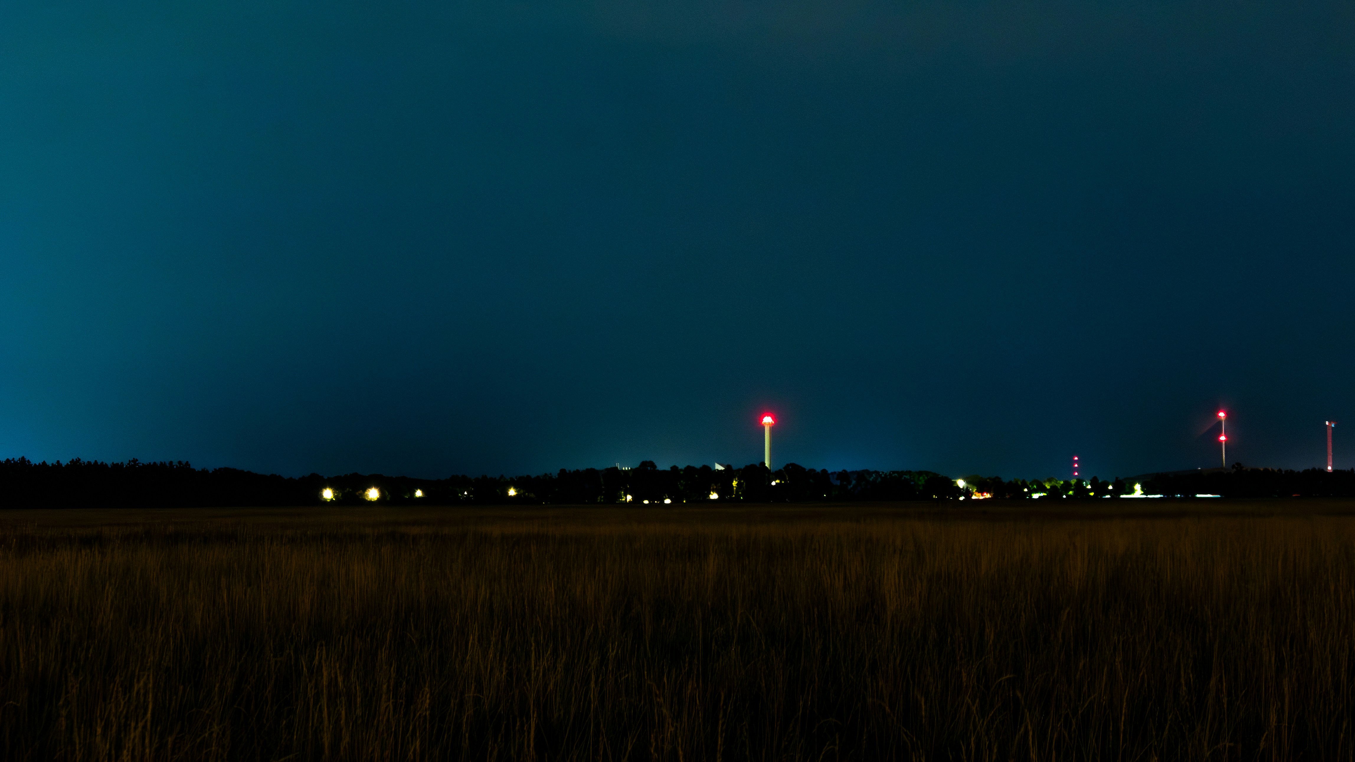 Distant illuminated buildings under a dark blue night sky