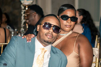 A man and woman wearing sunglasses at an event