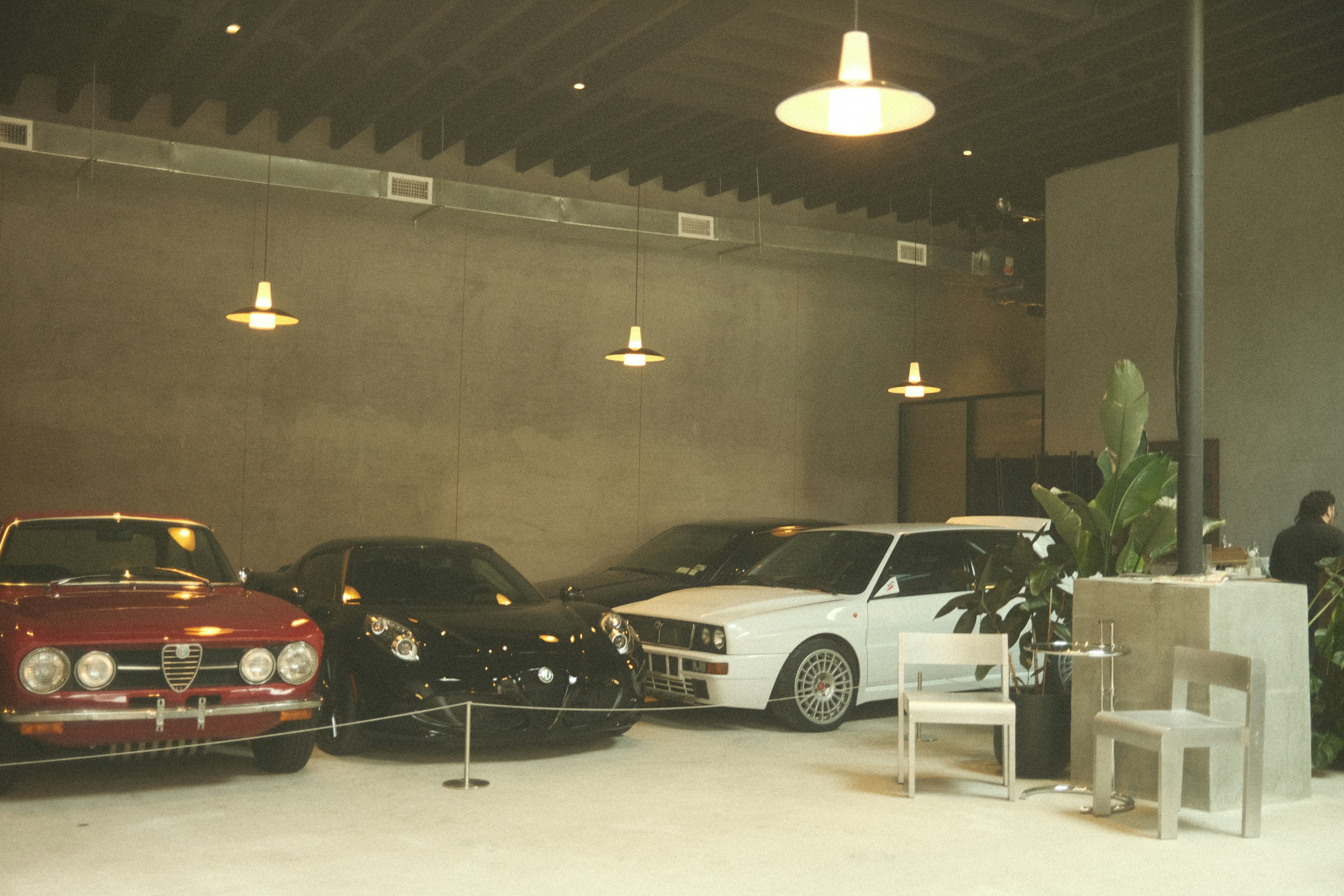 Auto d'epoca e moderne mostrate sotto luci sospese.