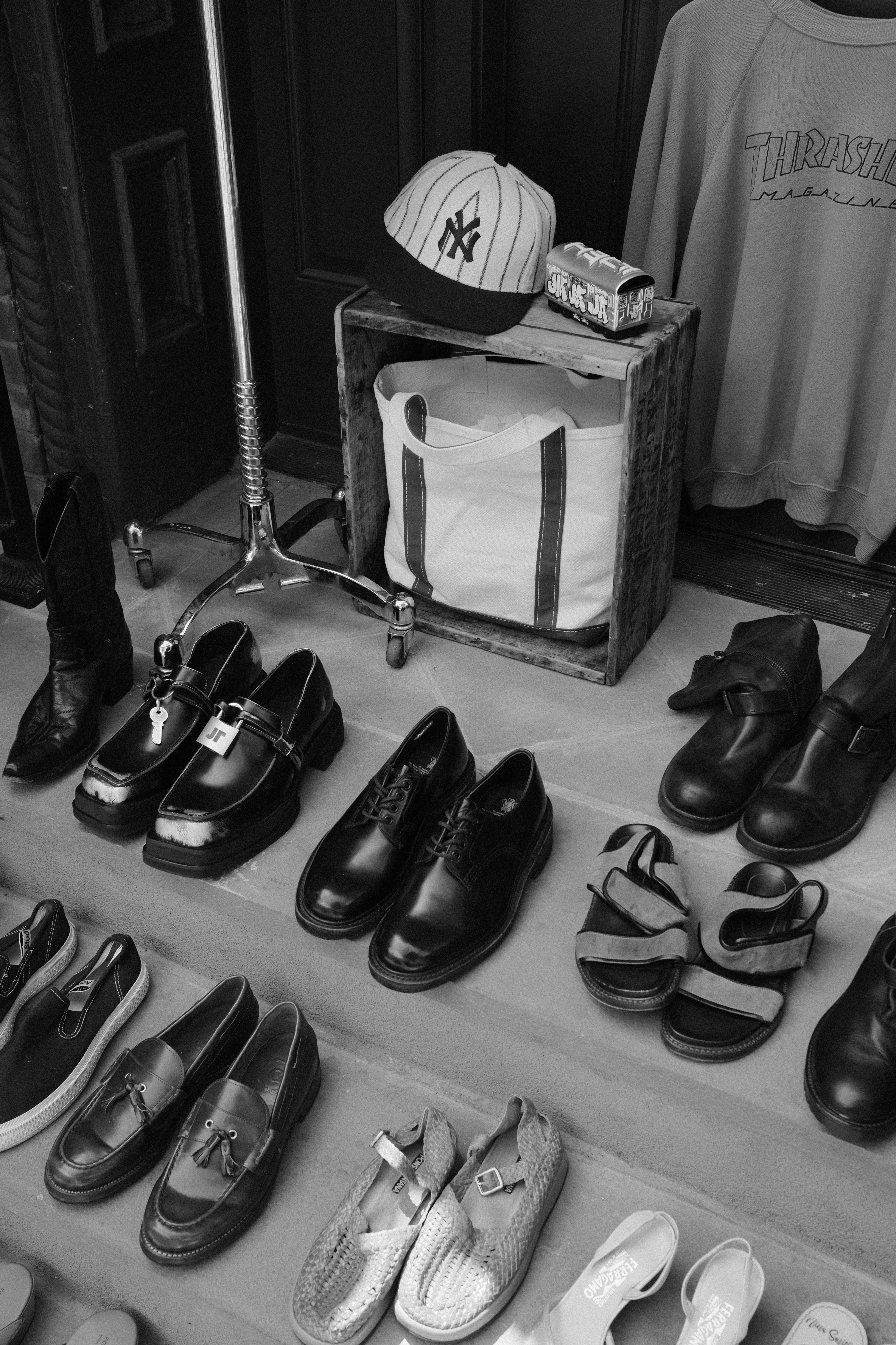 Varie scarpe e capi d'abbigliamento sono esposti sui gradini all'aperto.
