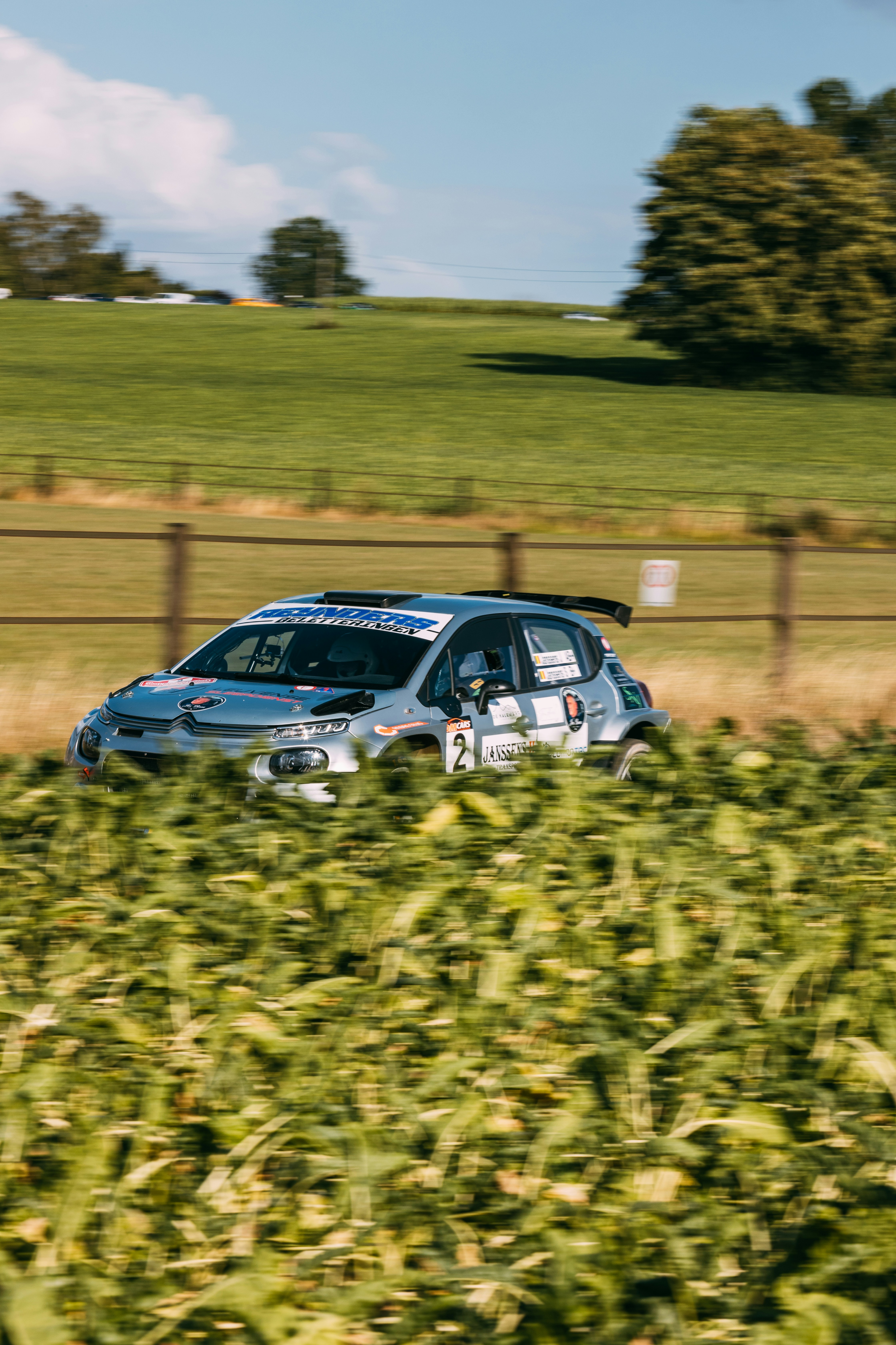 Velocità da rally tra campi verdi sotto un cielo azzurro