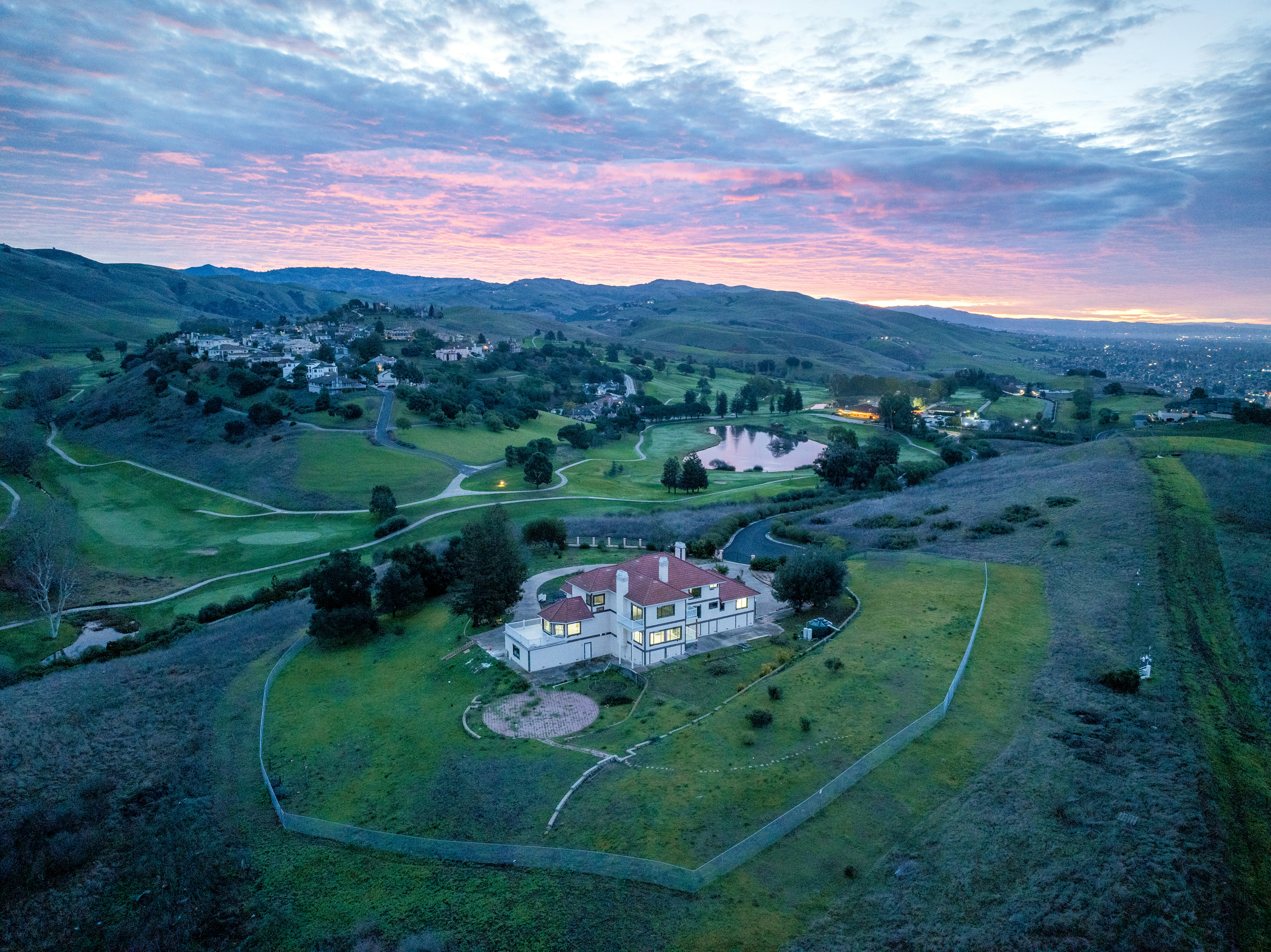 Estate on a golf course under a colorful sunset