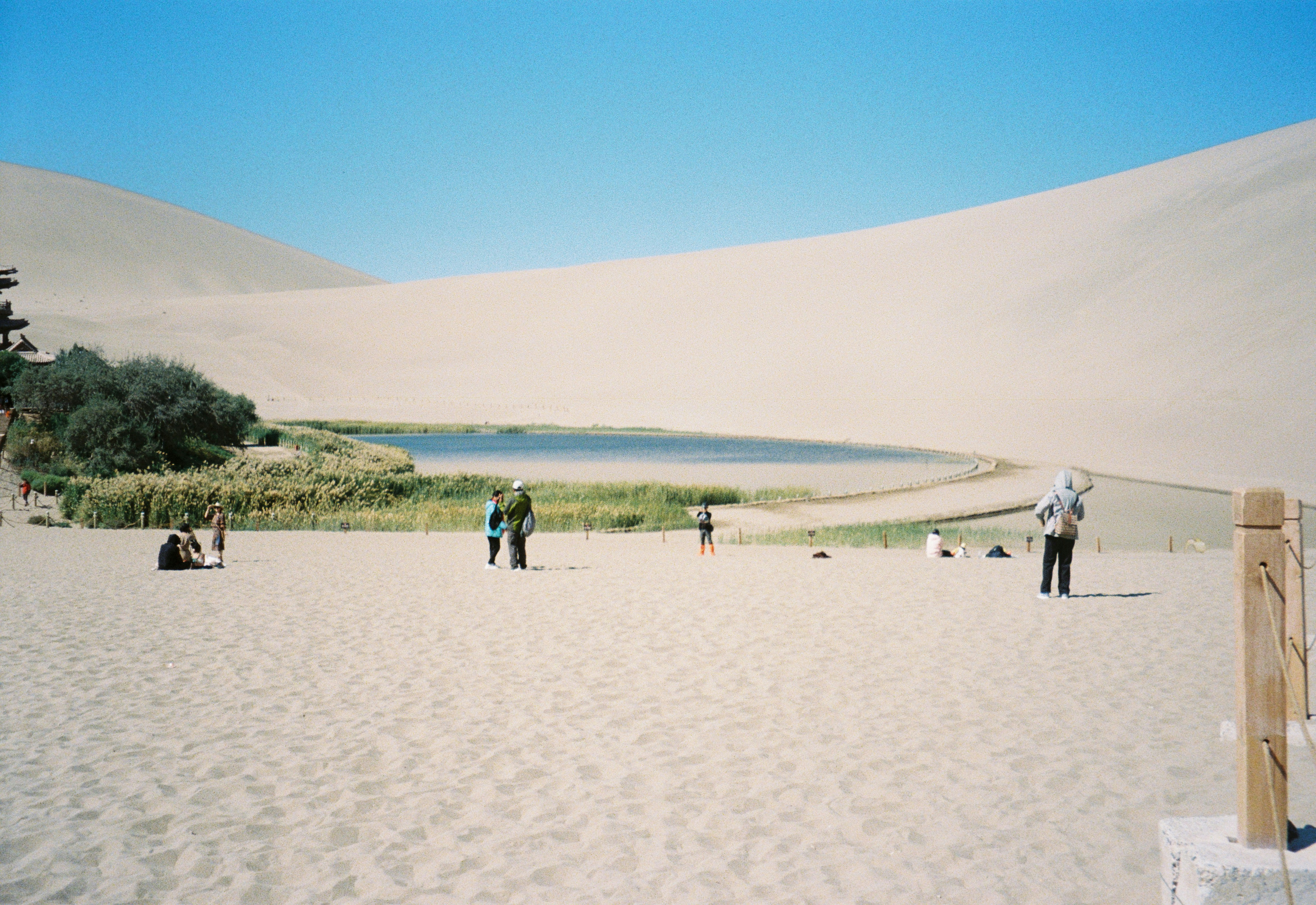Desert oasis with sand dunes and people