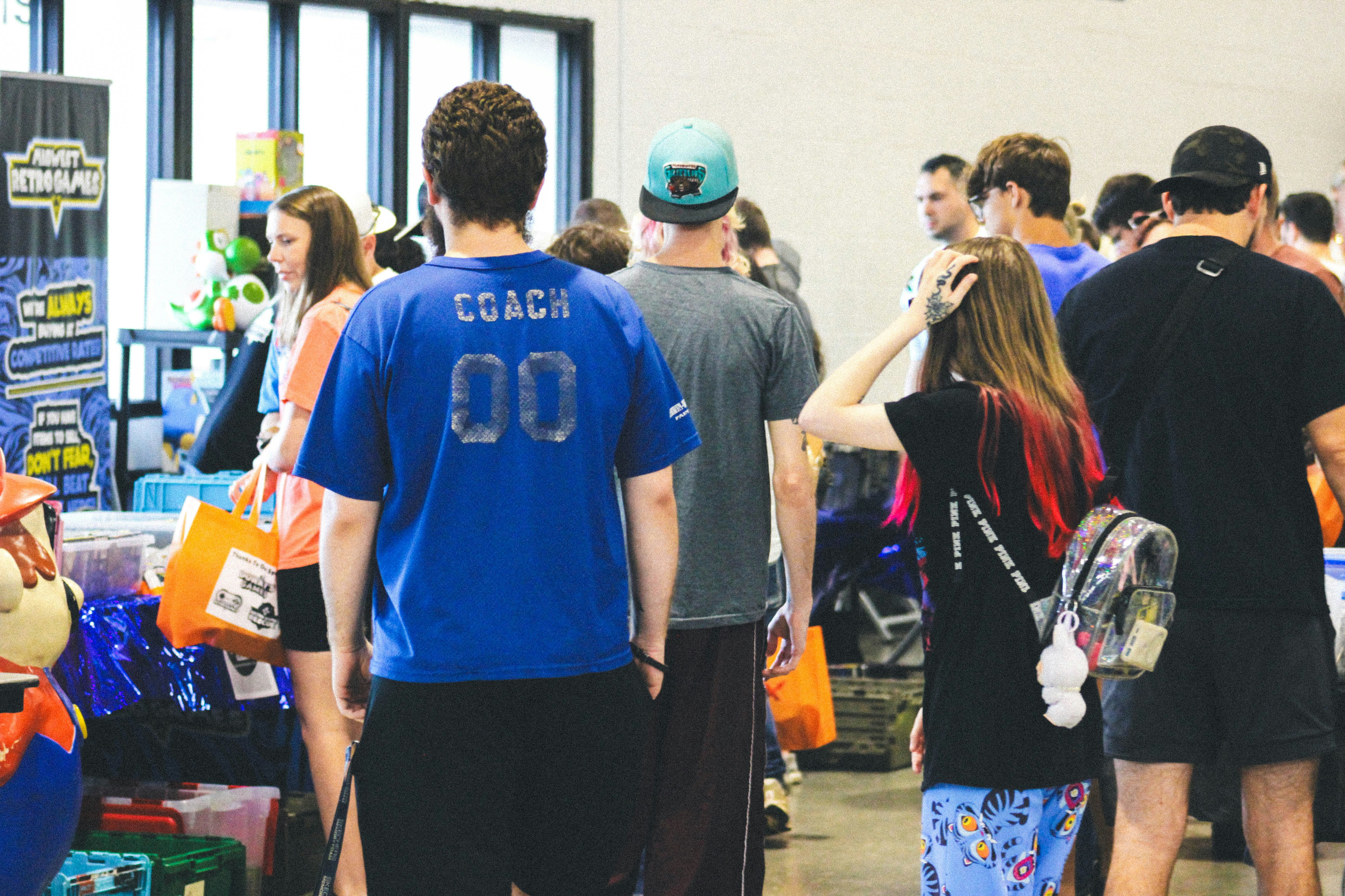 People walking through an indoor event with various displays