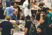 Many people browse items at a crowded indoor convention