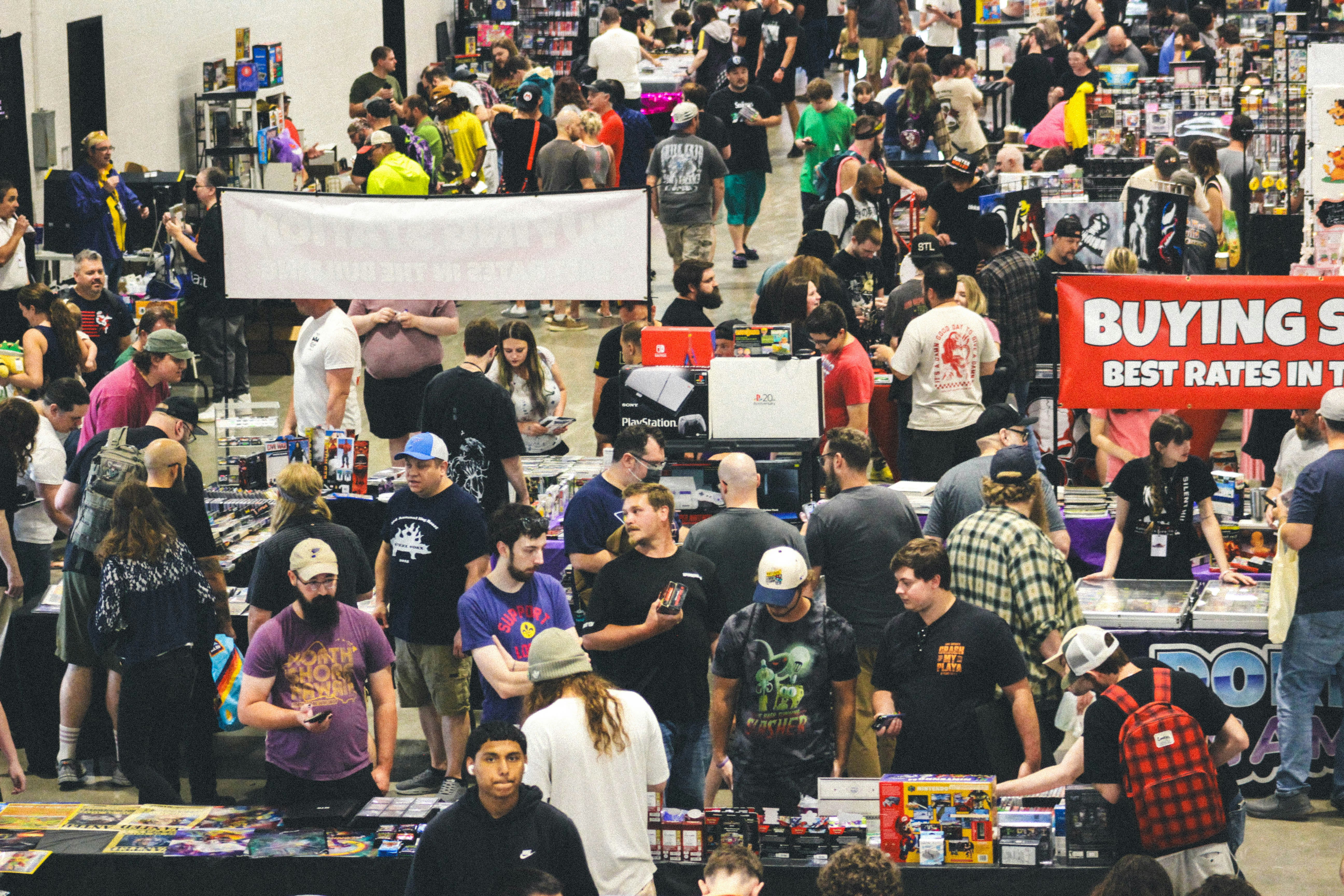 A large crowd of people at a busy indoor convention
