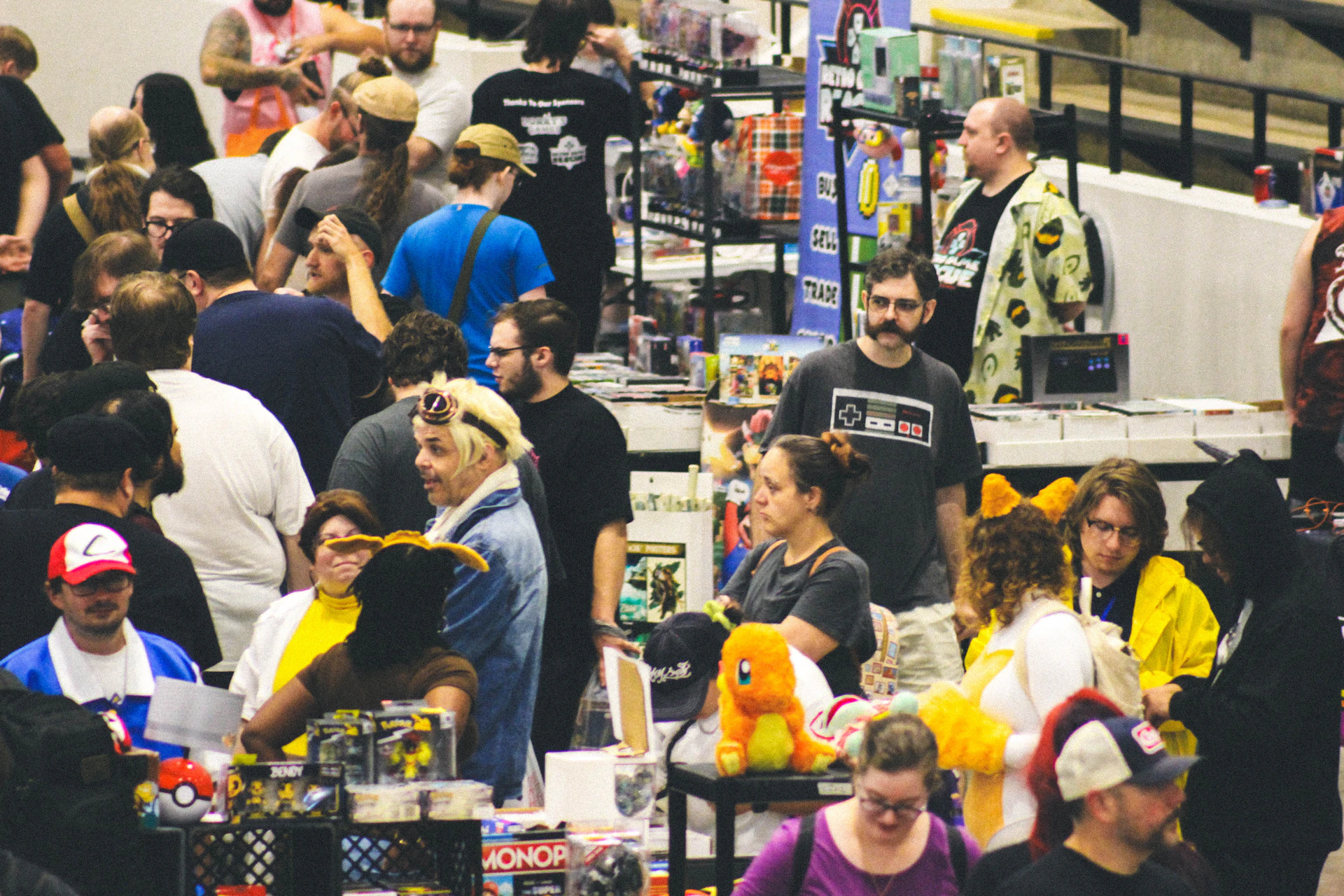 Many people browsing merchandise at a busy indoor convention