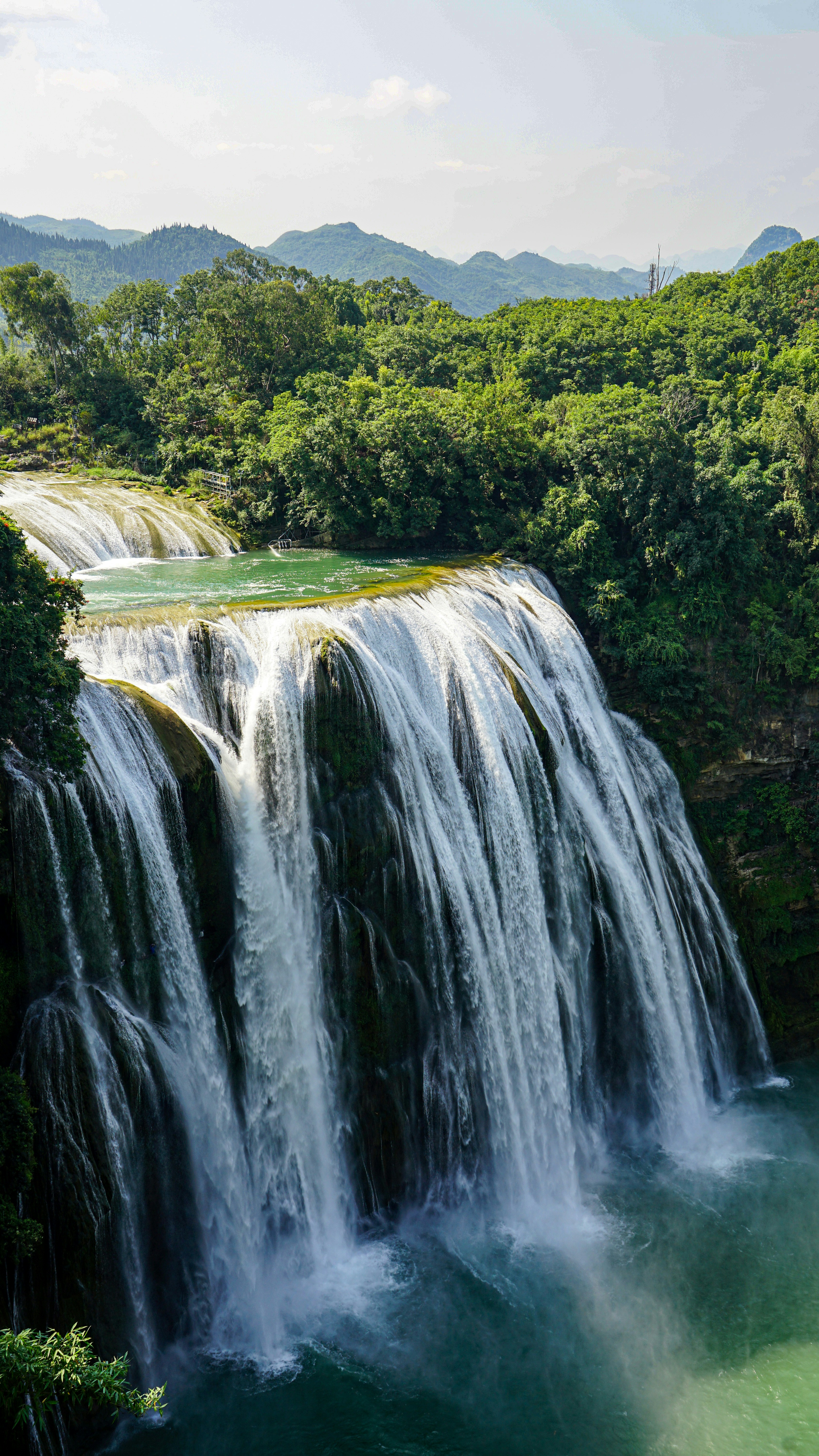 Paisaje verde y exuberante con una poderosa cascada que desemboca.