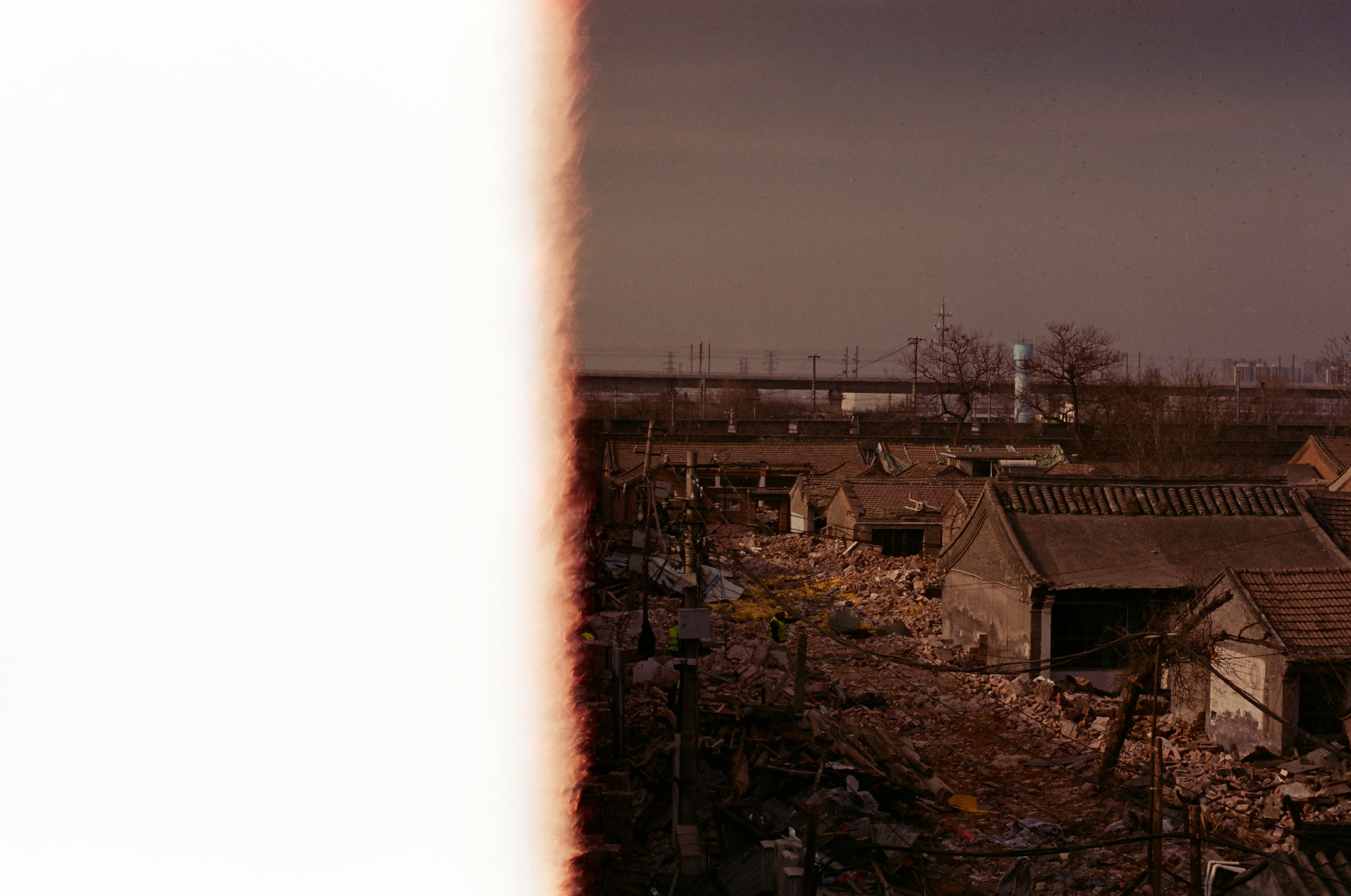 Light leak over dilapidated buildings and an elevated bridge