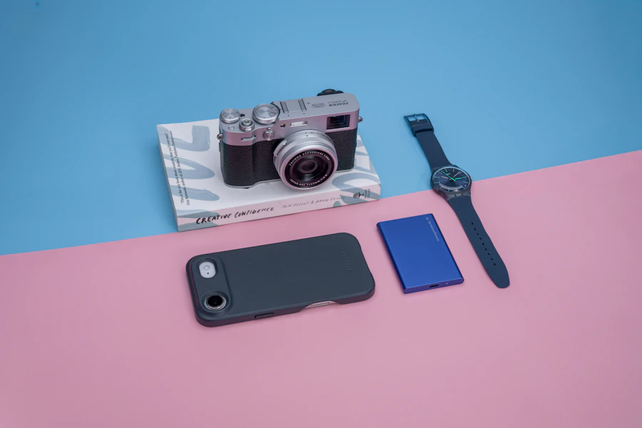Camera, phone and watch on a pink and blue surface