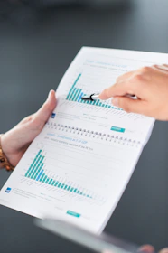Hands pointing at data charts in a document.