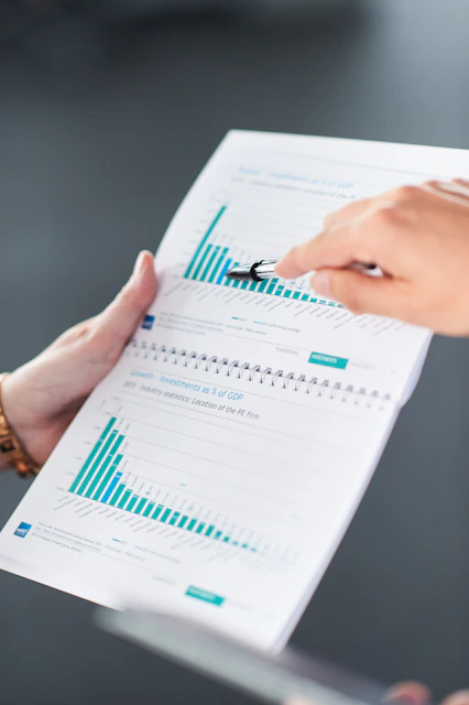 Hands pointing at data charts in a document.
