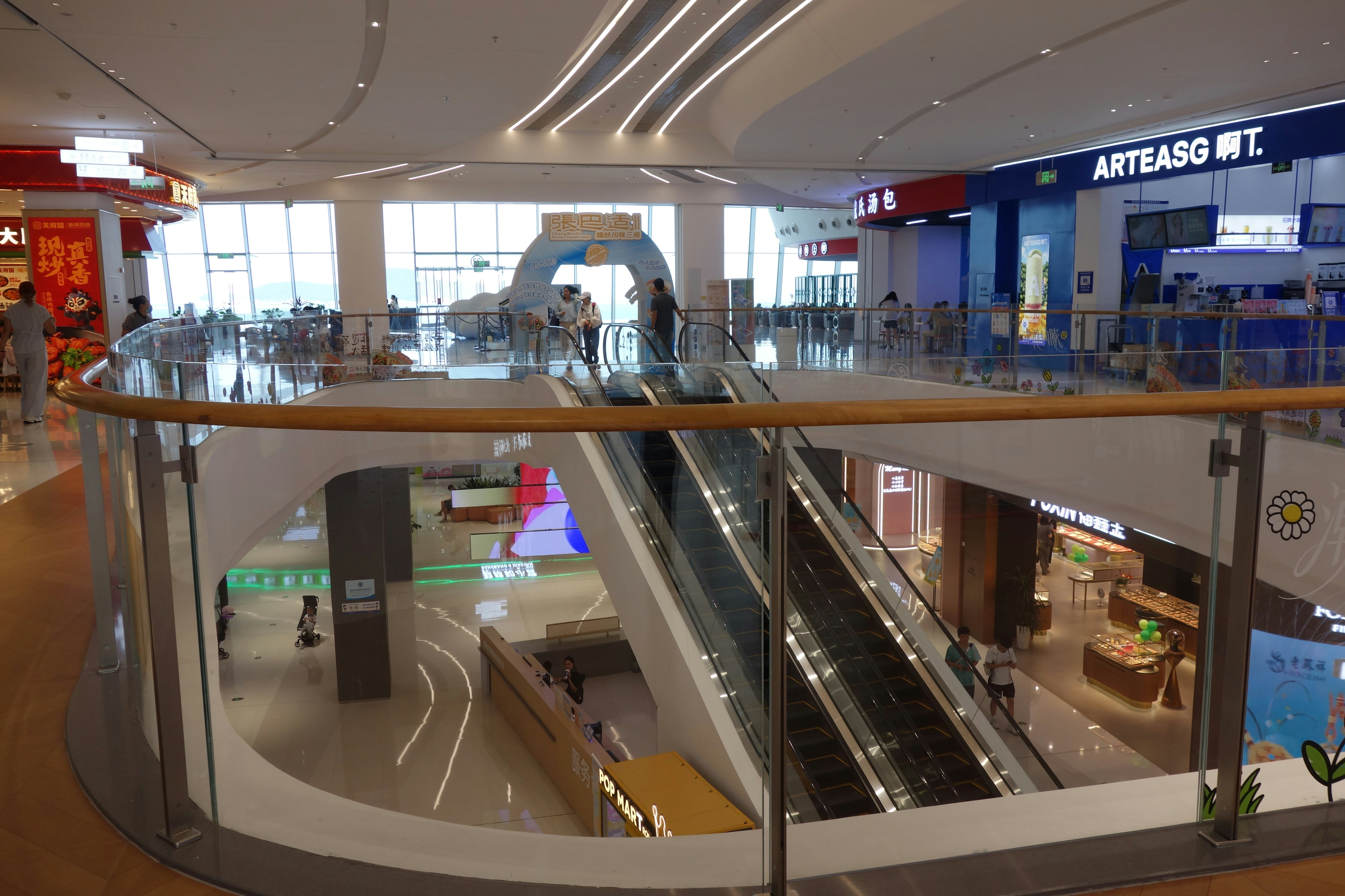 Modern shopping centre with escalators and glass balustrades