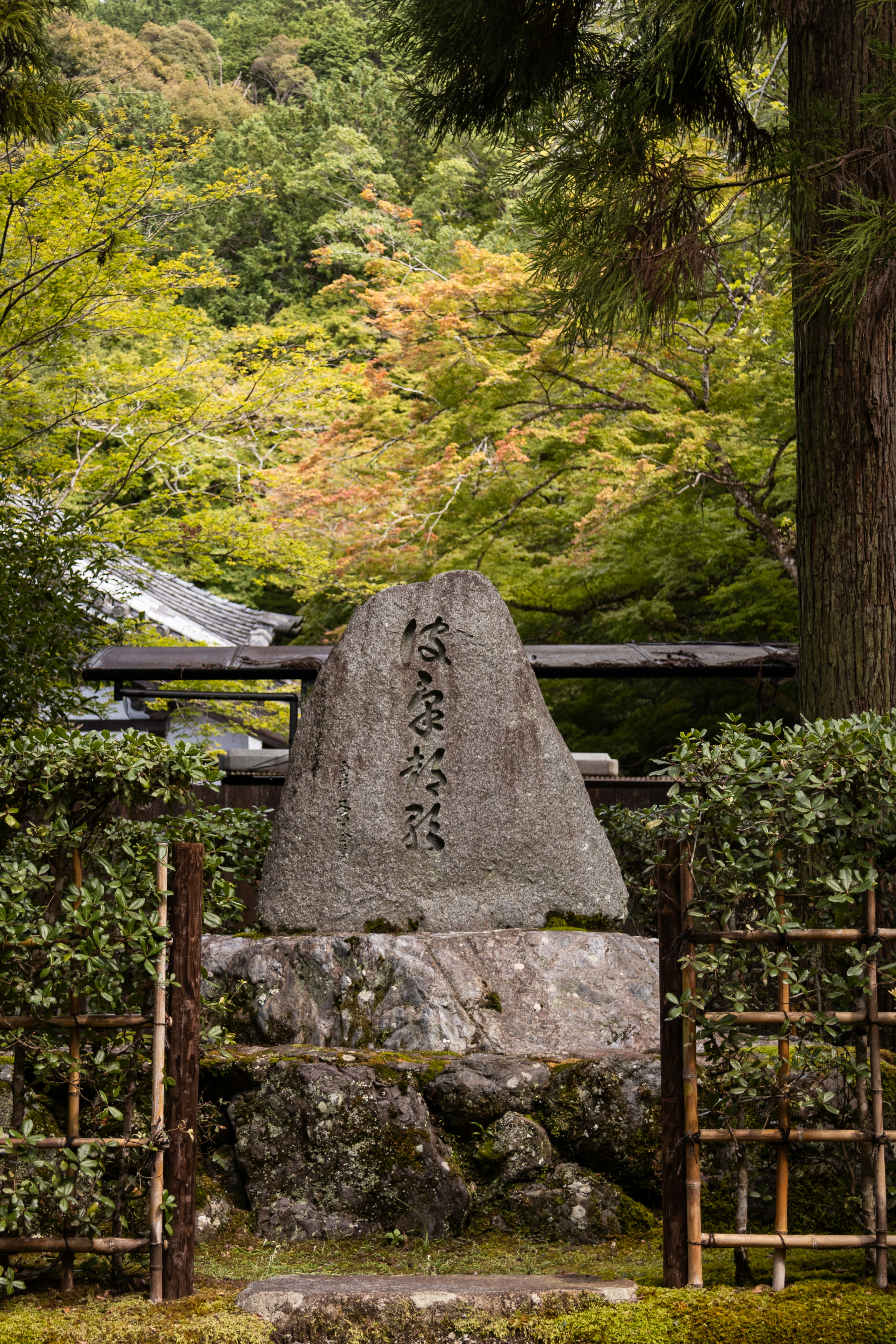 Ancient stone monument with calligraphy in a serene japanese garden