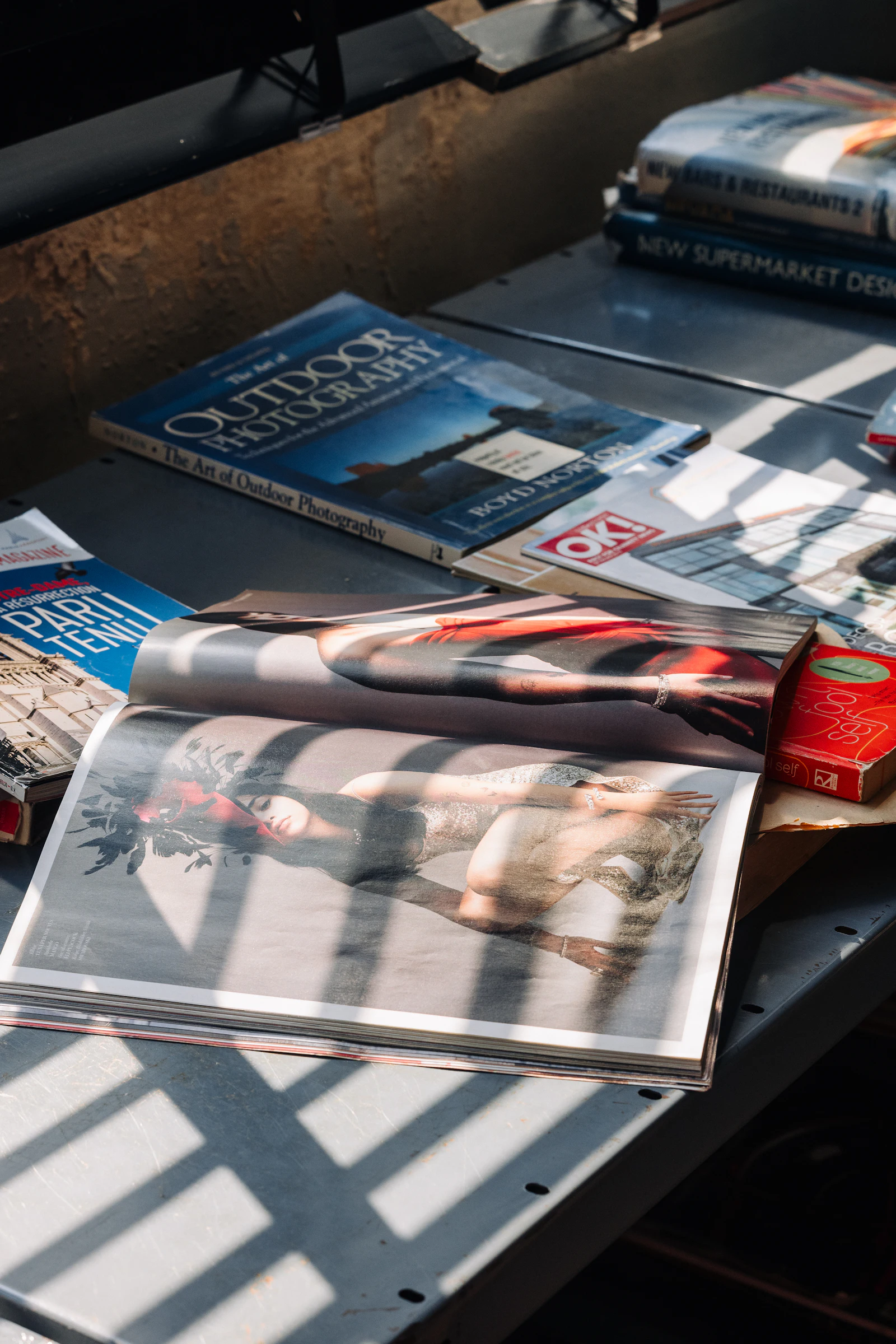 Sunlight casting striped shadows across magazines on a table