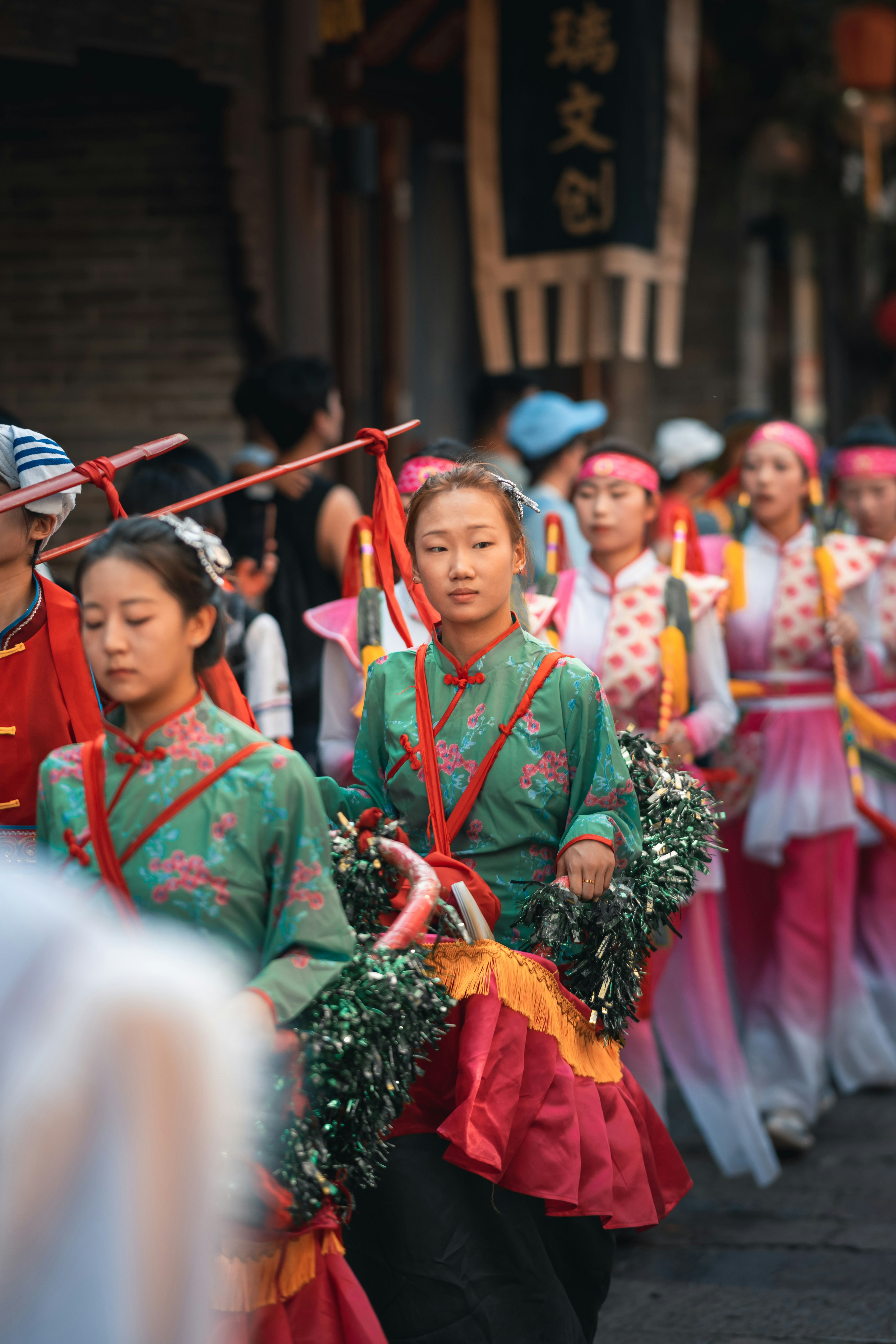 Processione festosa di donne in vivaci costumi tradizionali.