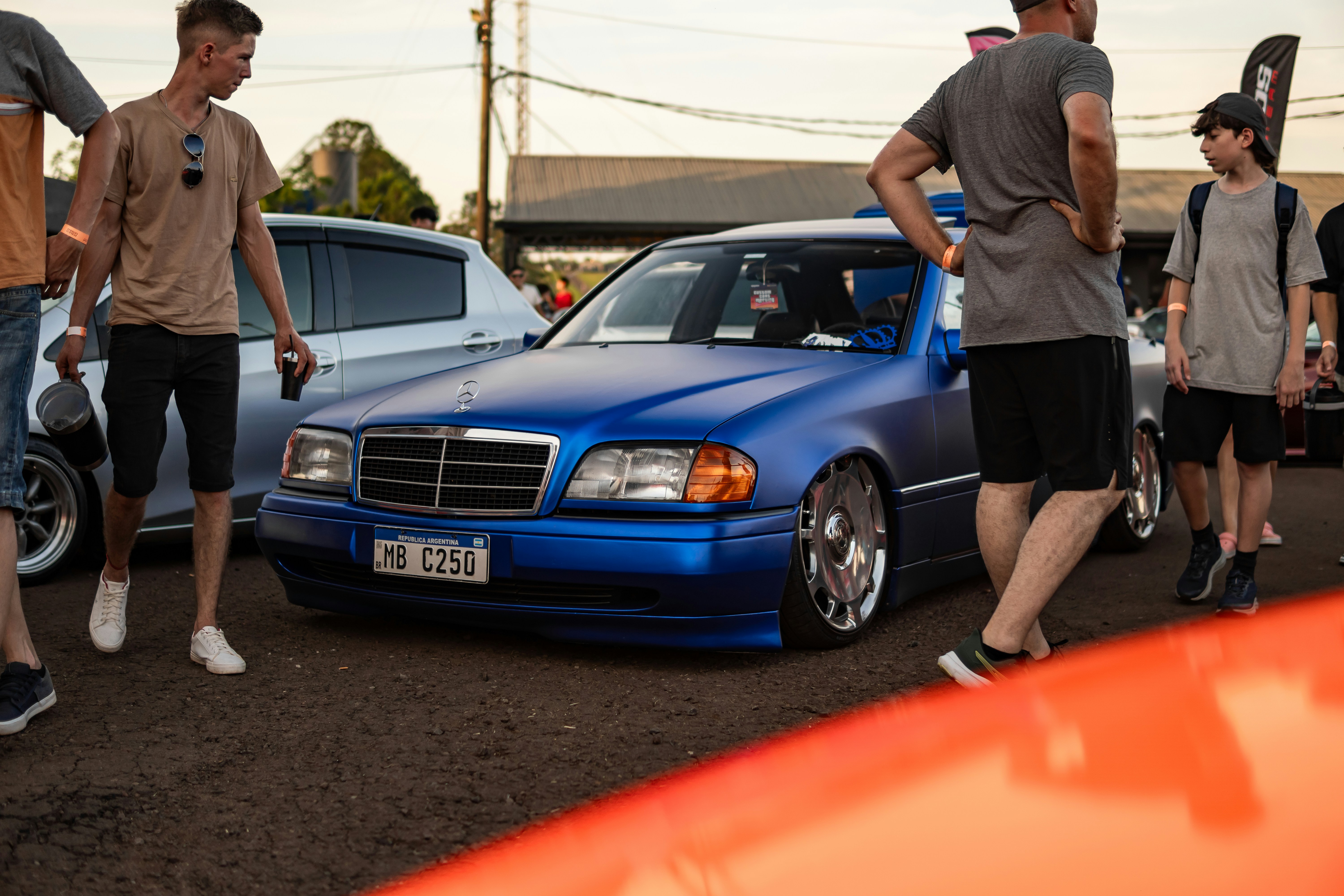 Mercedes-Benz azul modificado cercado de pessoas.