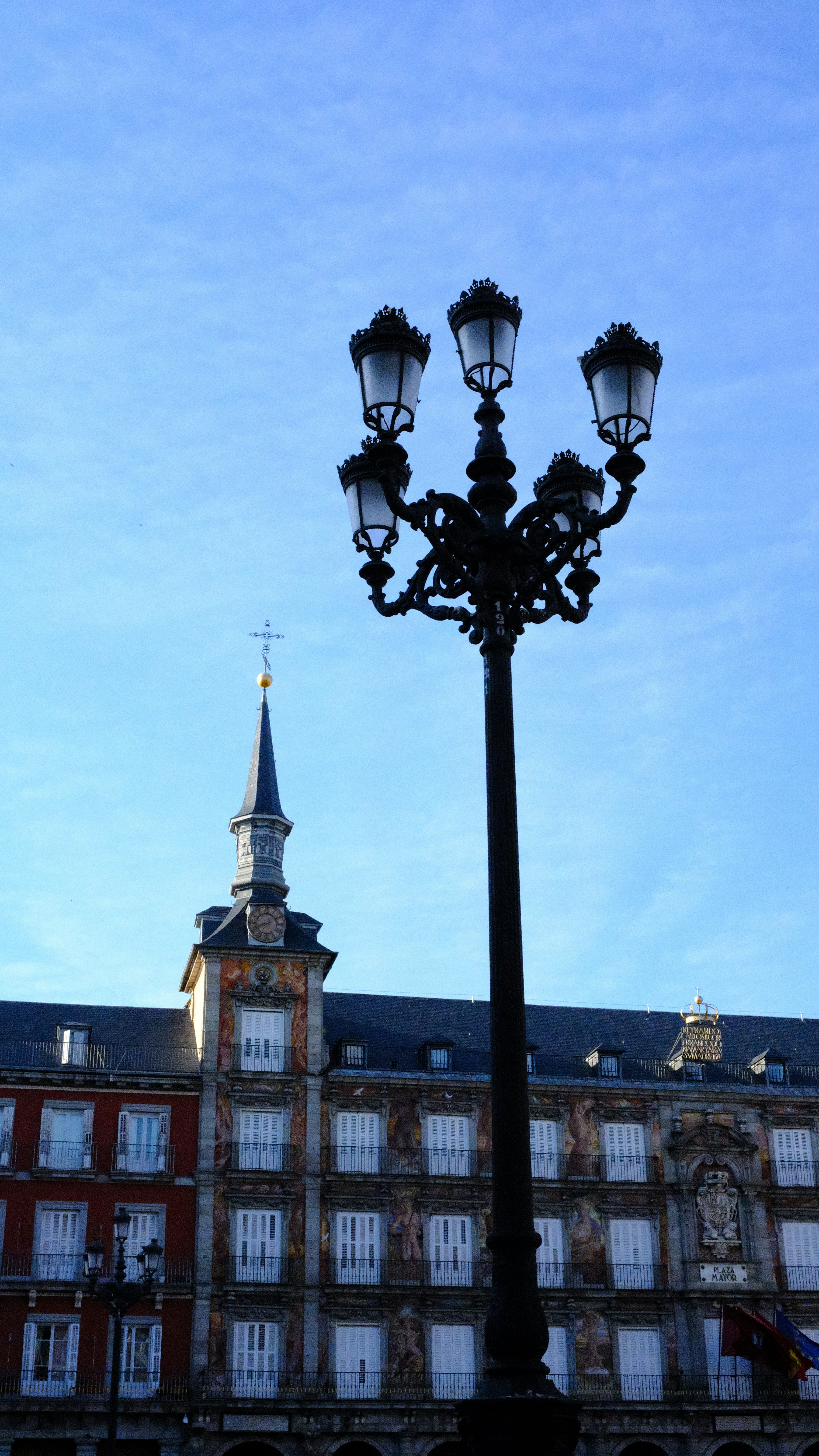 Historic building and ornate street lamp against a blue sky.