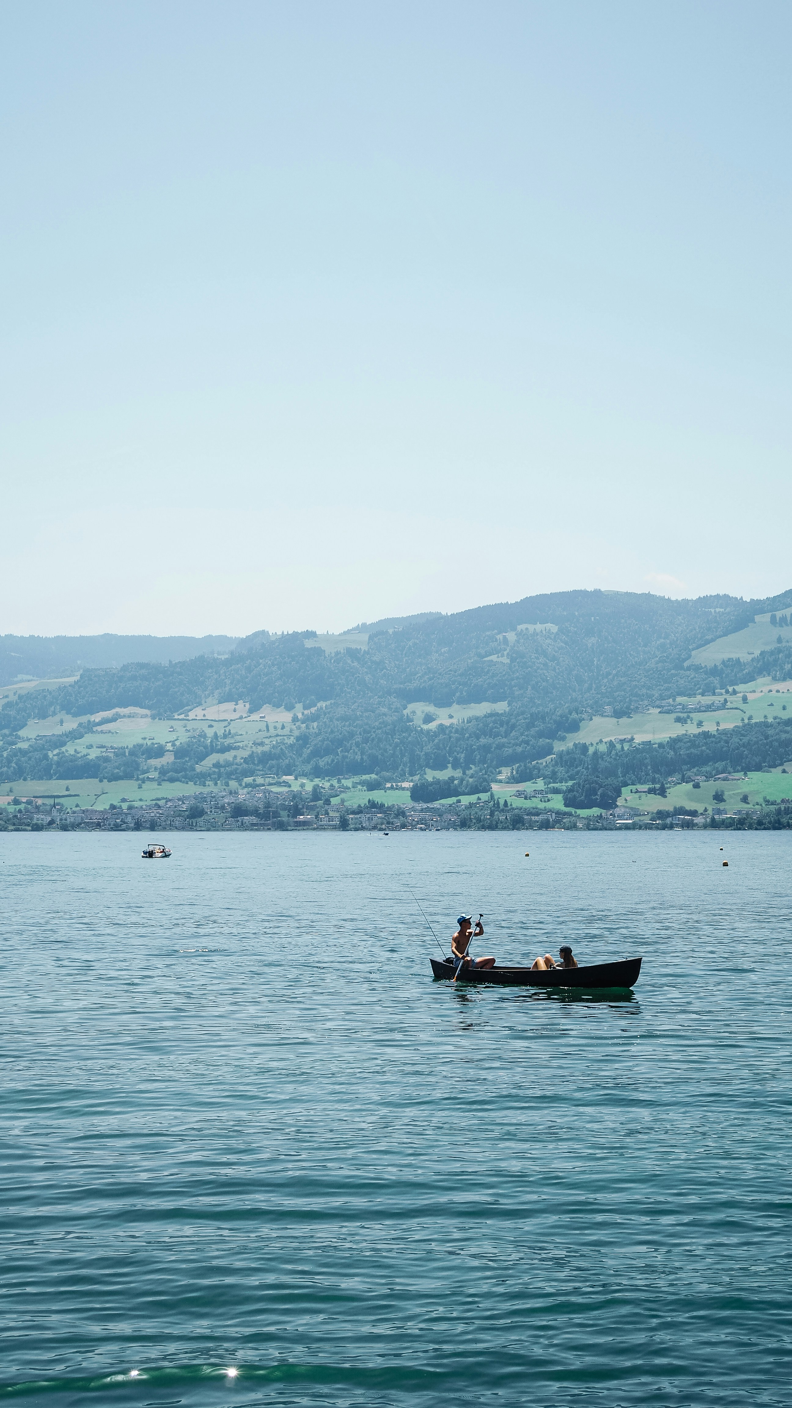 Two people in a rowboat on a calm lake.
