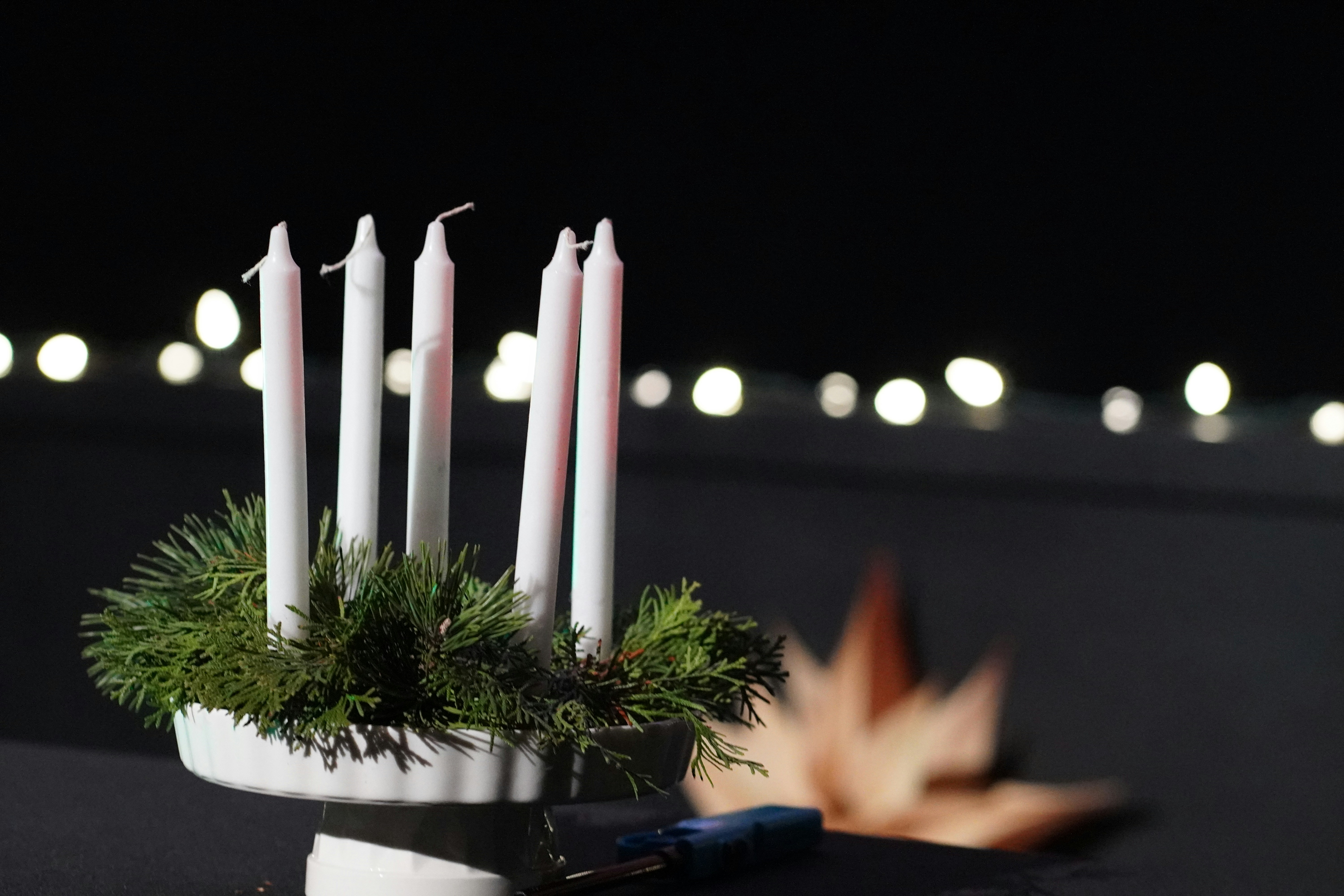 Five white candles in a green fir wreath.